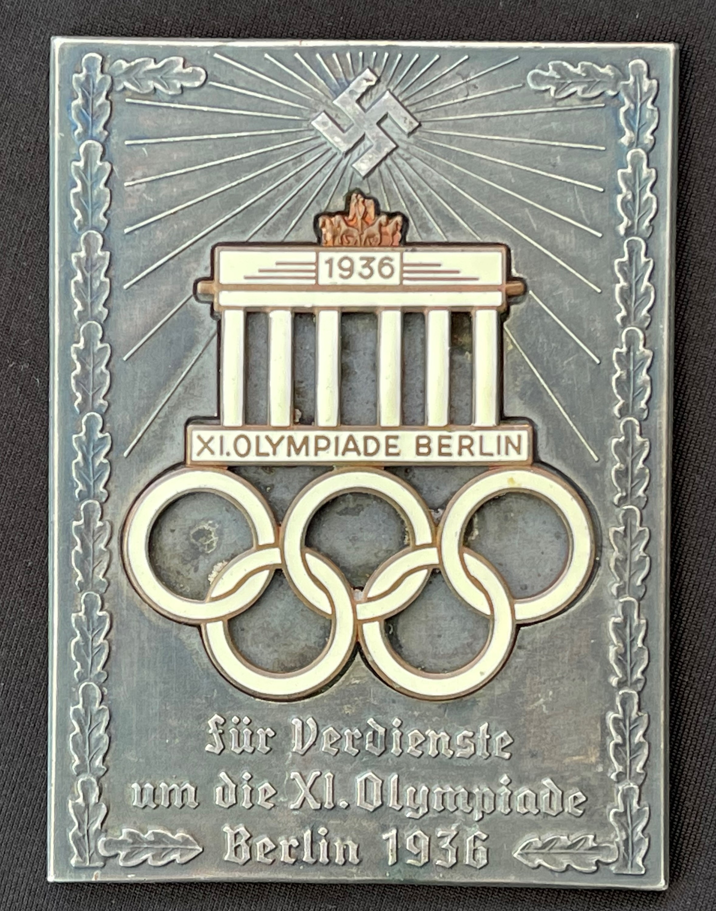 WW2 Third Reich 1936 XI Olympiade Berlin non portable award. Inscribed "Fur Verdienste um die XI Olympiade Berlin 1936". Two part construction with Enamel Brandenburg Gate and Olympic Rings. Size approx. 95mm x 70mm.