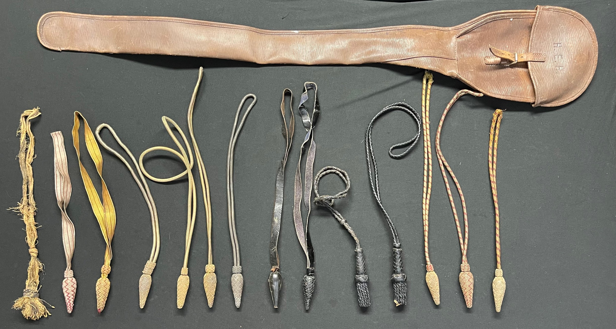 A collection of 15 Georgian and later Victorian British Swords Knots and a leather Sword Cover with owners initials "HEH" to cover.