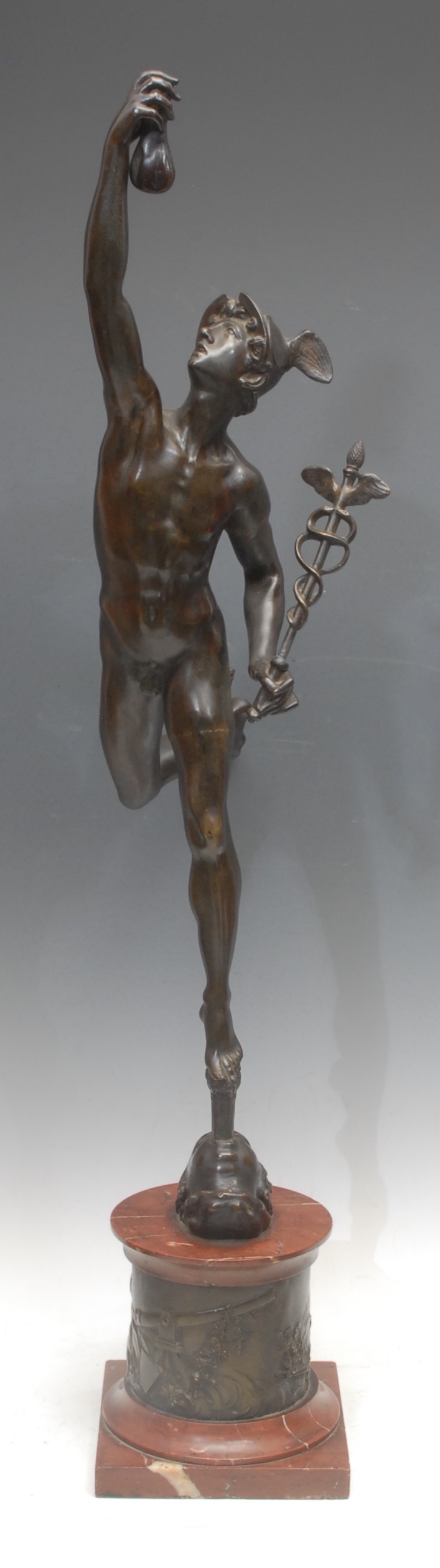 Giambologna (1529-1608) after, a figural bronze, of Mercury, veined red marble and bronze mounted pedestal base cast in bas-relief with putti at play, 82cm high overall