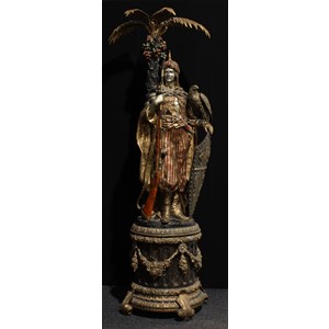 K. Namphet (contemporary) a substantial Orientalist polychrome decorated gilt and silvered bronze figure, as an Ottoman janissary, he stands with a falcon, shield and rifle, before a palm tree, Neoclassical plinth, 225cm high
