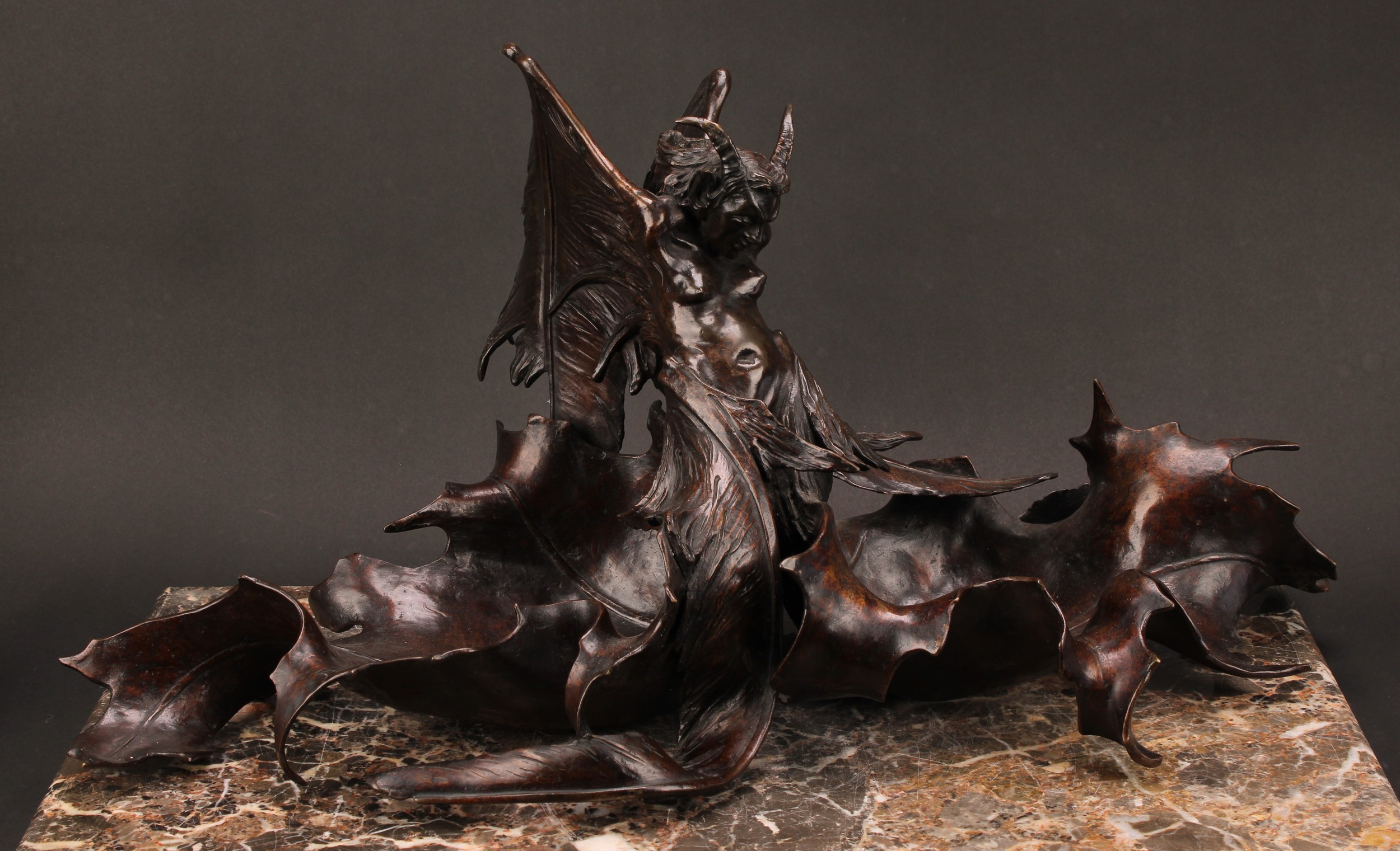Rinaldo Carnielo (Italian 1853 - 1910), an Art Nouveau brown patinated bronze table centre, cast as a fantastical winged figure, signed in the maquette and dated 1883, foundry mark of Fonderia Carradori, Pistoia, 63cm wide