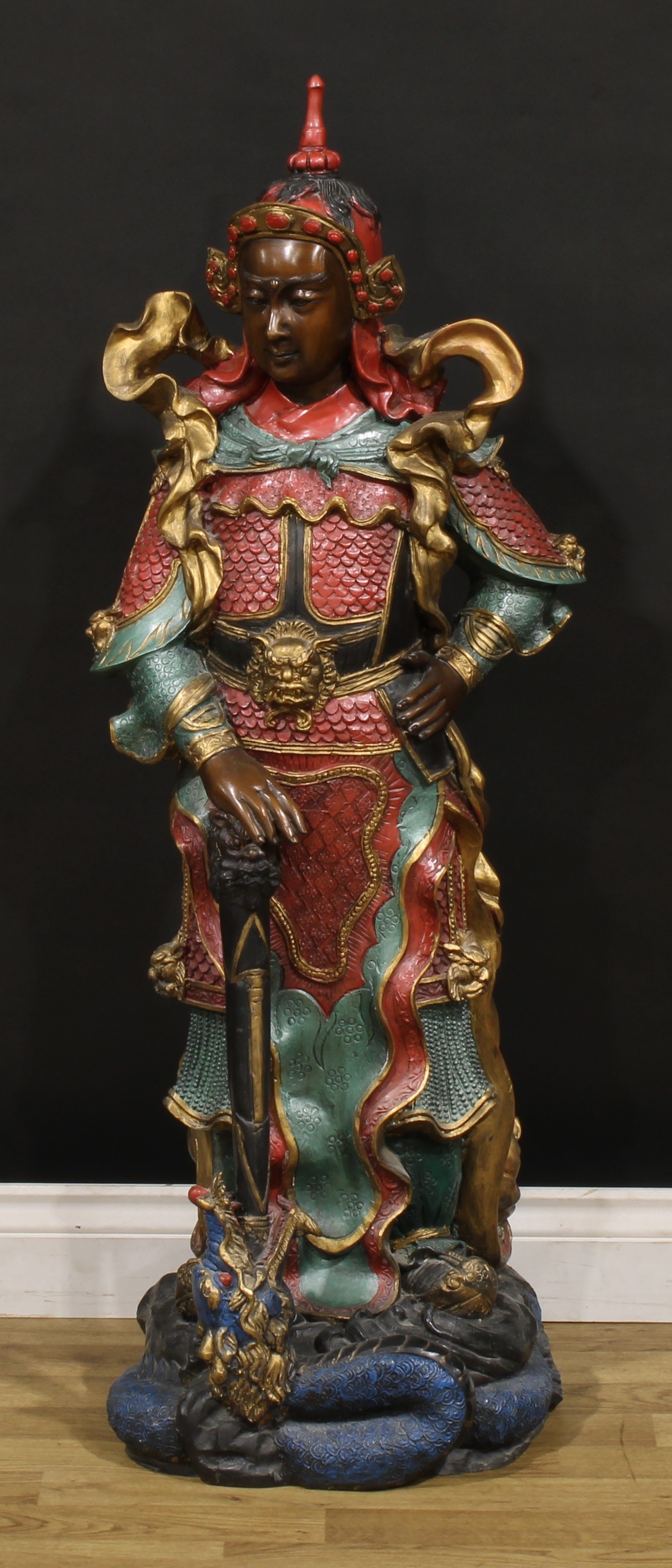 A large painted bronze, of a Japanese warrior, he stands in battle dress with a dragon at his feet, 112cm high, 20th century