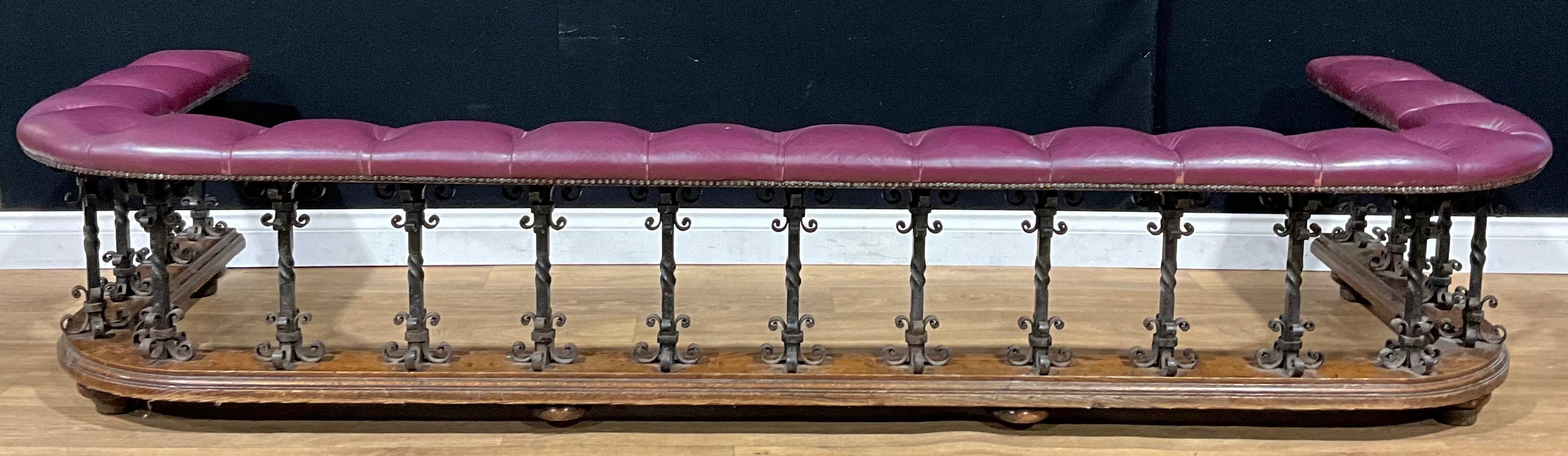 An Arts & Crafts period oak and wrought iron club fender, 49.5cm high, 254.5cm wide, 92cm deep, c.1910