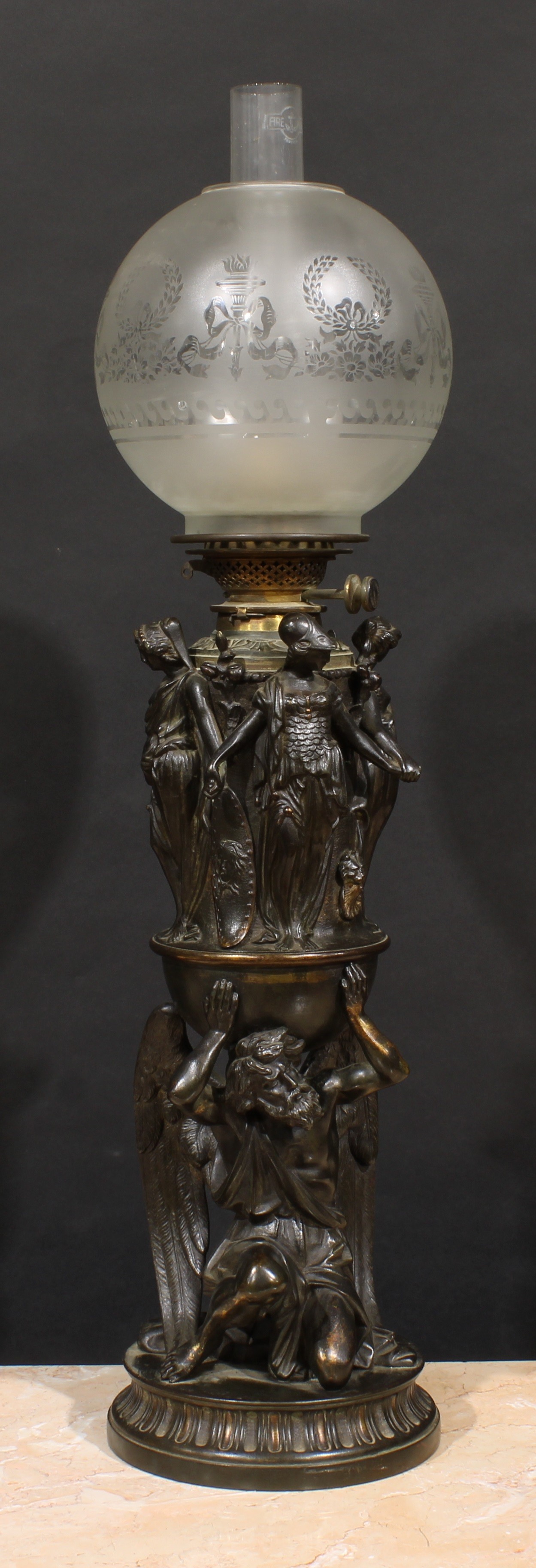 A substantial 19th century Renaissance Revival dark patinated bronze table oil lamp, cast with the kneeling Chronos beneath a band of Classical figures, Hink's patent burner marked Gardner, London, etched glass globular shade, 78.5cm to tip of chimney, c.1880