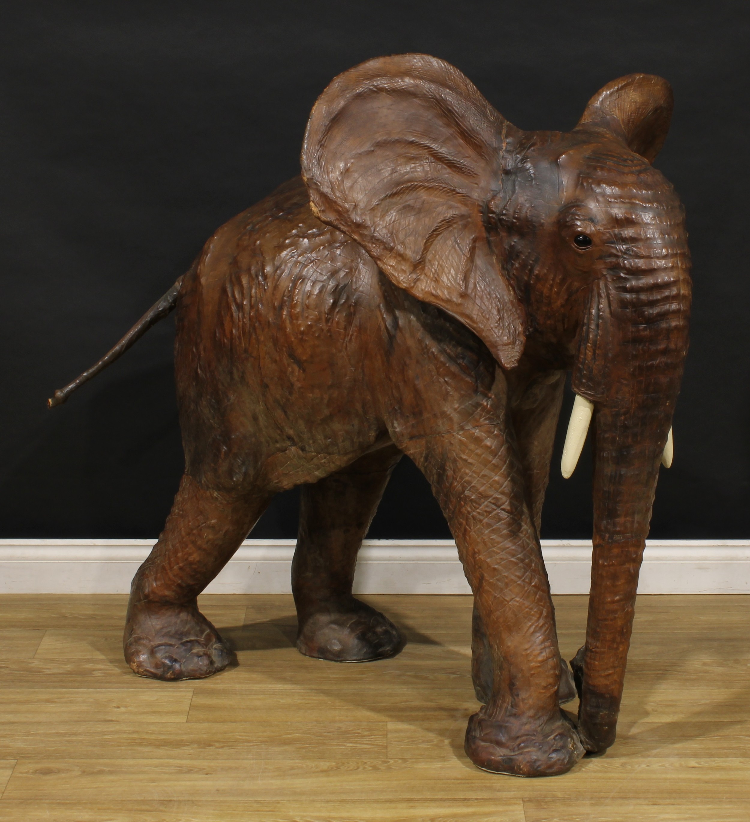A large mid-20th century leather wrapped model of an elephant, in the manner of Liberty, possibly a shop promotional model, 120cm high, 132cm long, 87cm wide