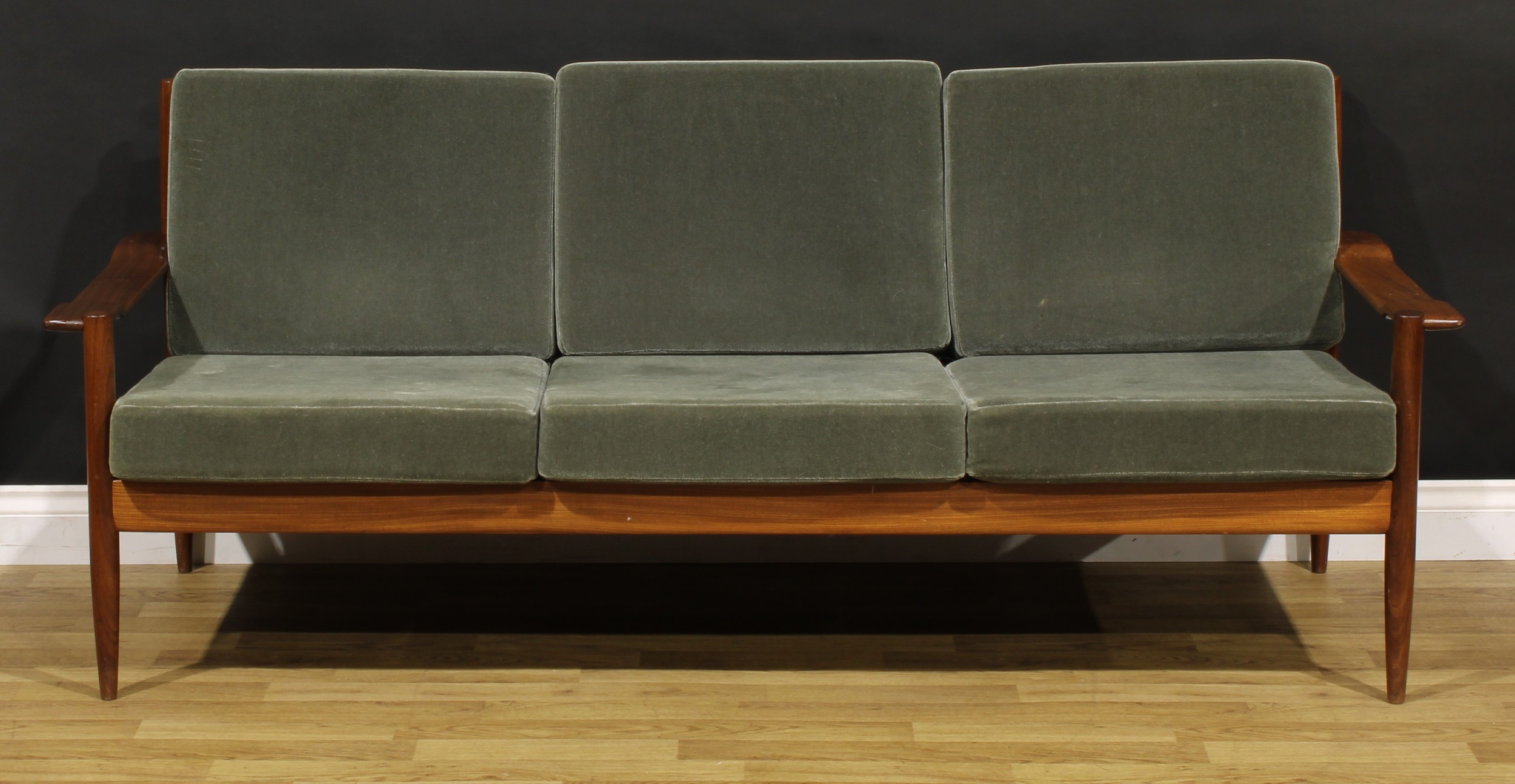 Mid-century Design - a teak sofa, by Walter Knoll (German, 1876-1971) for Knoll Antimott, 77cm high, 184cm wide, the seat 165cm wide and 53cm deep, c.1960  NB - This lot is offered for sale as a work of art, the cushions may not comply with the Furniture and Furnishings (Fire) Safety Regulations 1988 and for this reason should not be used in a private dwelling.
