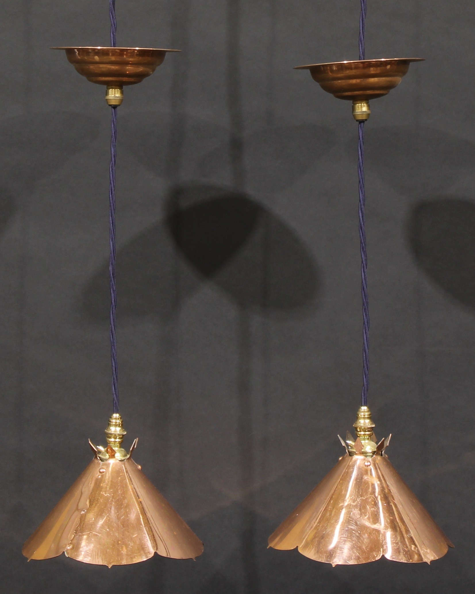 A pair of Arts & Crafts style copper conical flowerhead shaped ceiling pendants, in the manner of W.A.S. Benson, 18cm diameter