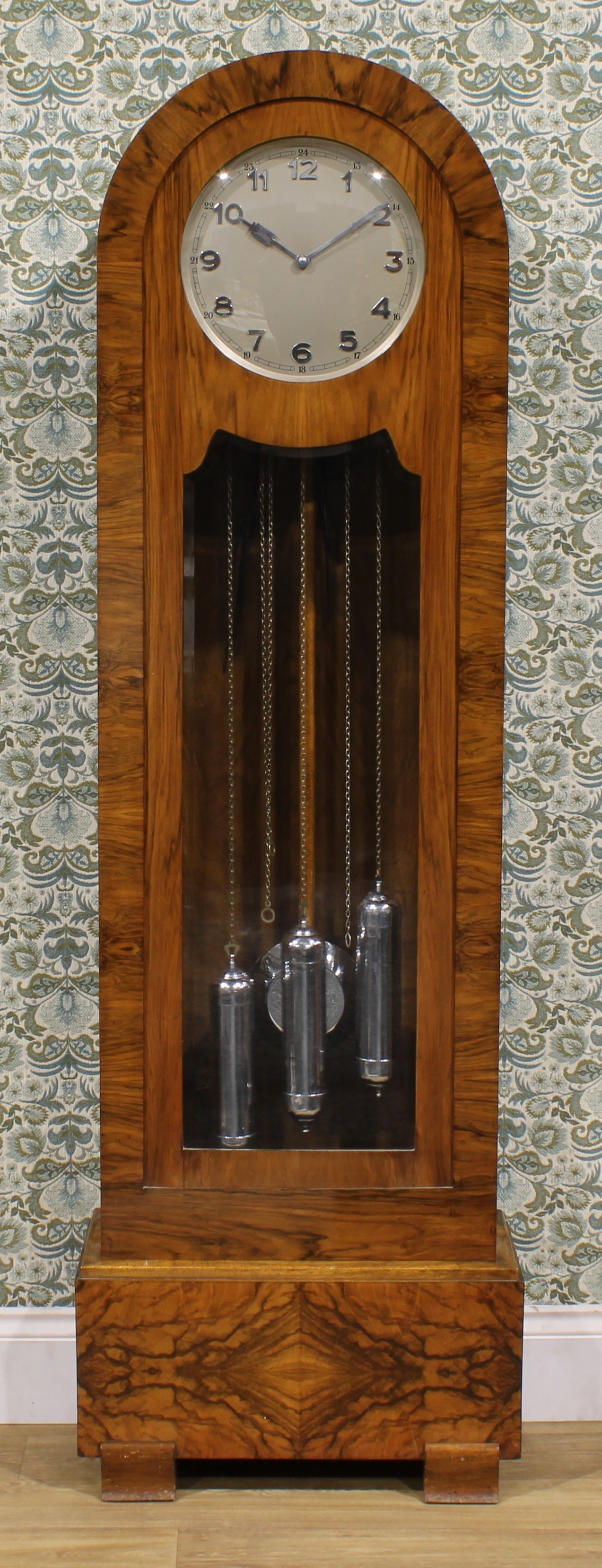 An Art Deco walnut longcase clock, 29.5cm dial applied and inscribed with Arabic numerals, eight day movement striking on rods, 192.5cm high, 60cm wide, 29cm deep, c.1925