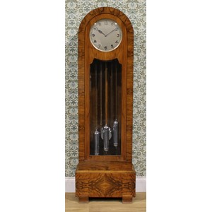 An Art Deco walnut longcase clock, 29.5cm dial applied and inscribed with Arabic numerals, eight day movement striking on rods, 192.5cm high, 60cm wide, 29cm deep, c.1925