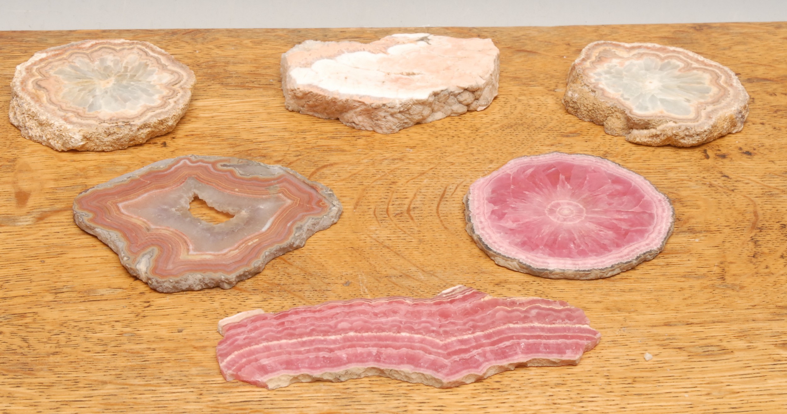 Geology - a rhodochrosite polished geode specimen, approx. 9cm diameter; another, 14.7cm wide; an agate geode specimen slice, approx. 8cm diameter; other unpolished agate slices (6)  Provenance: From the private rock and mineral collection of the late Annie Kyte, deceased