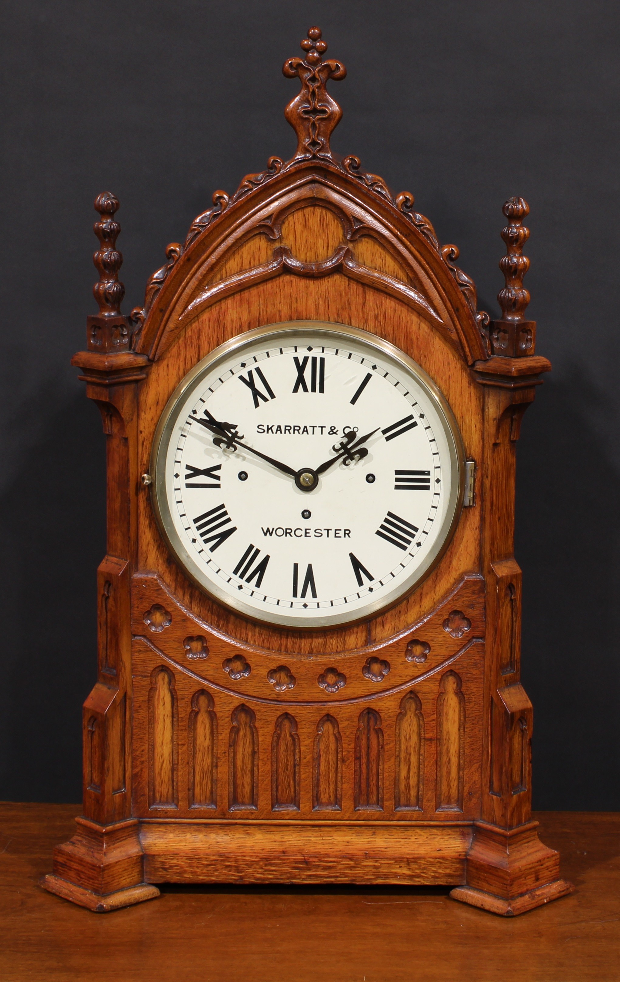 A large late Victorian Gothic Revival architectural wimperg shaped mantel clock, 24.5cm dial inscribed SKARRATT & CO WORCESTER, triple winding holes, eight day fusee movement striking on a nest of eight bells and a gong, 76cm high, 47cm wide, 25.5cm deep, c.1890