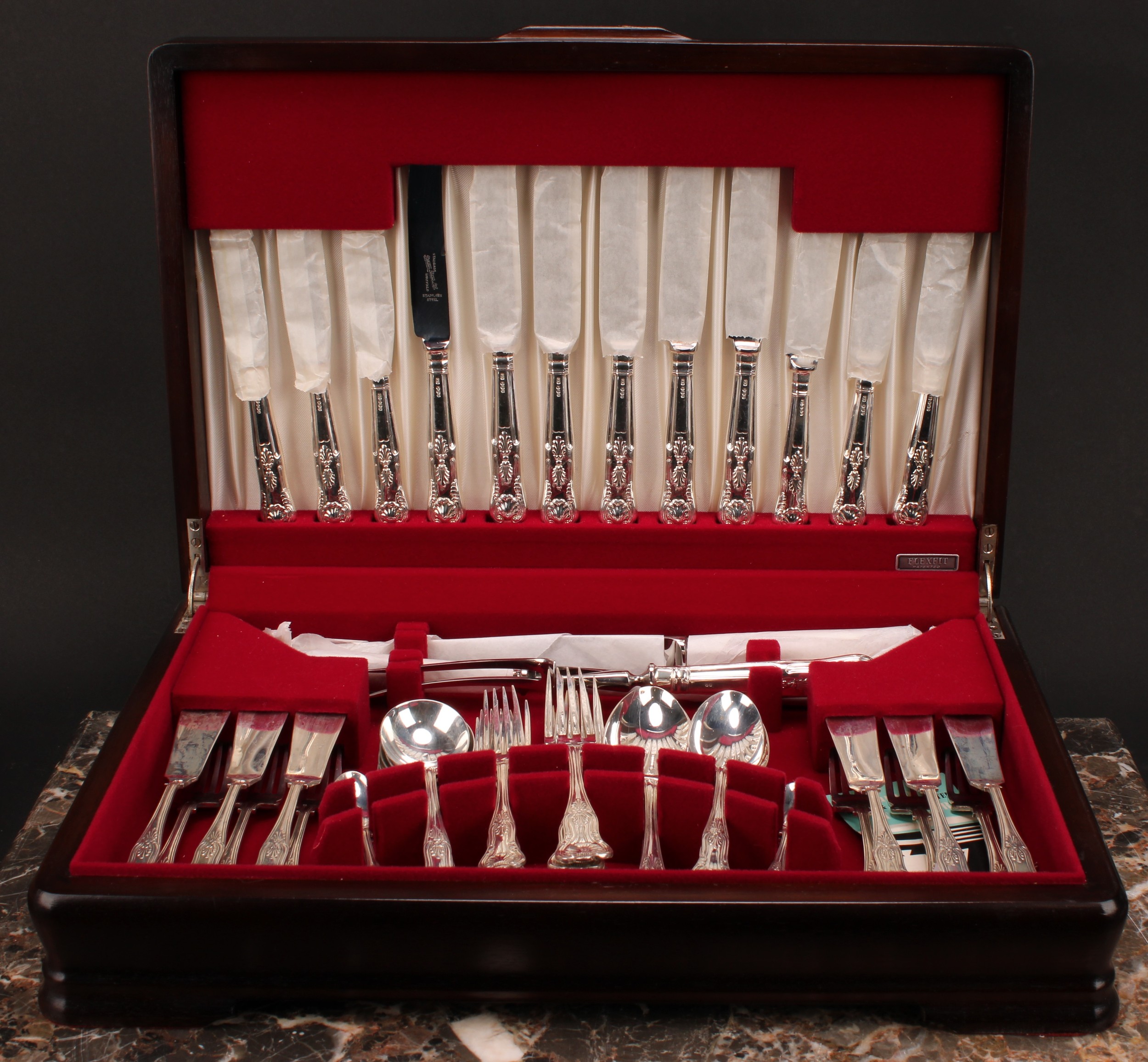 An Elizabeth II silver Kings pattern canteen of flatware, for six, comprising soup spoons, table knives and forks, dessert knives and forks, dessert spoons, fish knives and forks, teaspoons, a pair of serving spoons and a carving set, Pinder Brothers, Sheffield 1975, cased, 2700g weighable silver