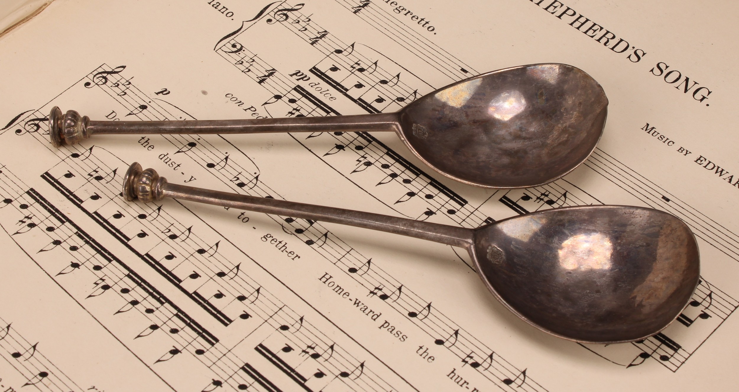 A pair of Charles I silver seal top spoons, tapering stem above fig shaped bowl, engraved baluster finial with flat disc X crossed terminal, hallmarked London, 1627, 15.4cm long, (2)
