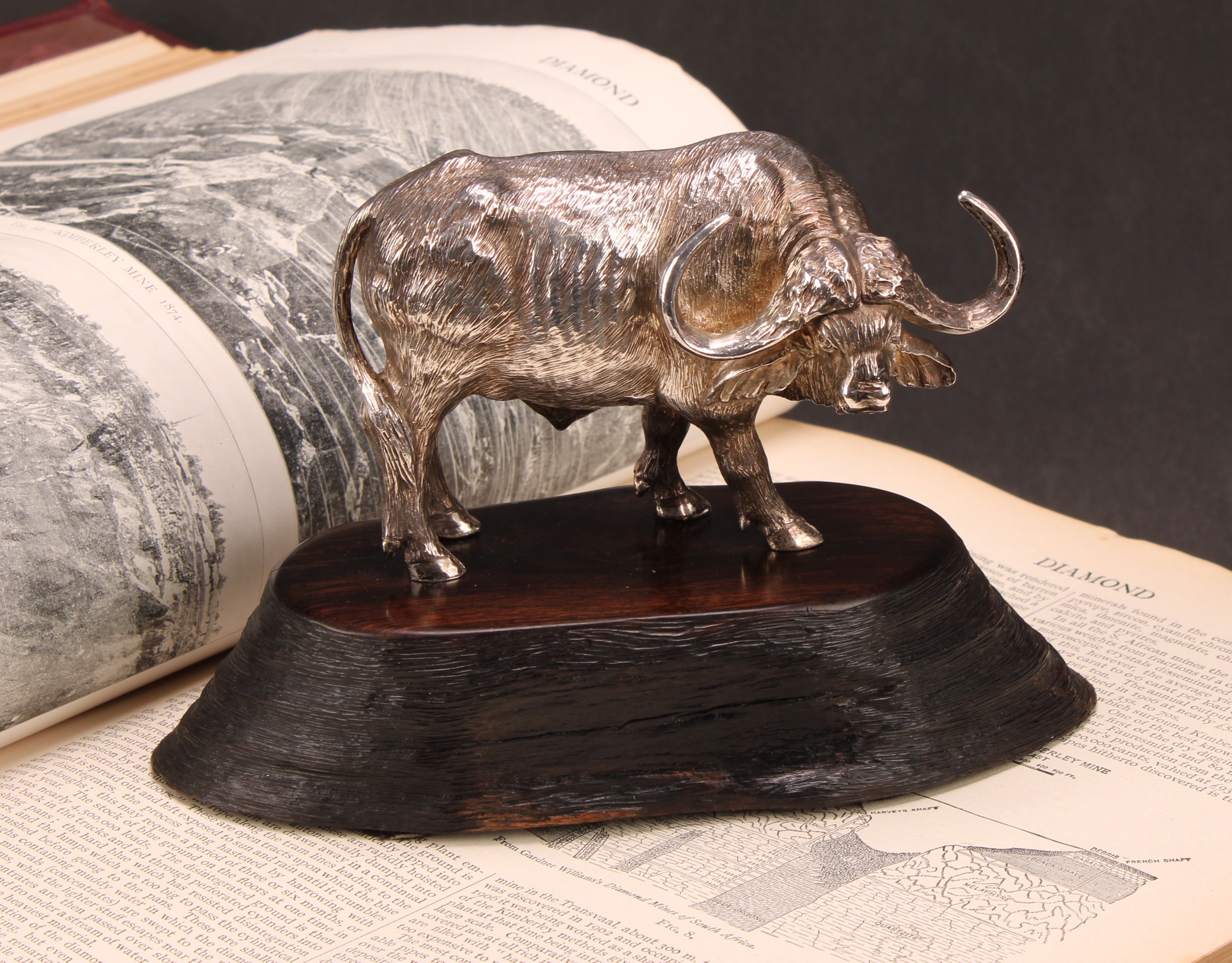Patrick Mavros - a South African cast silver model, of a buffalo, 12cm long, 296g, hardwood stand, 16.5cm long overall