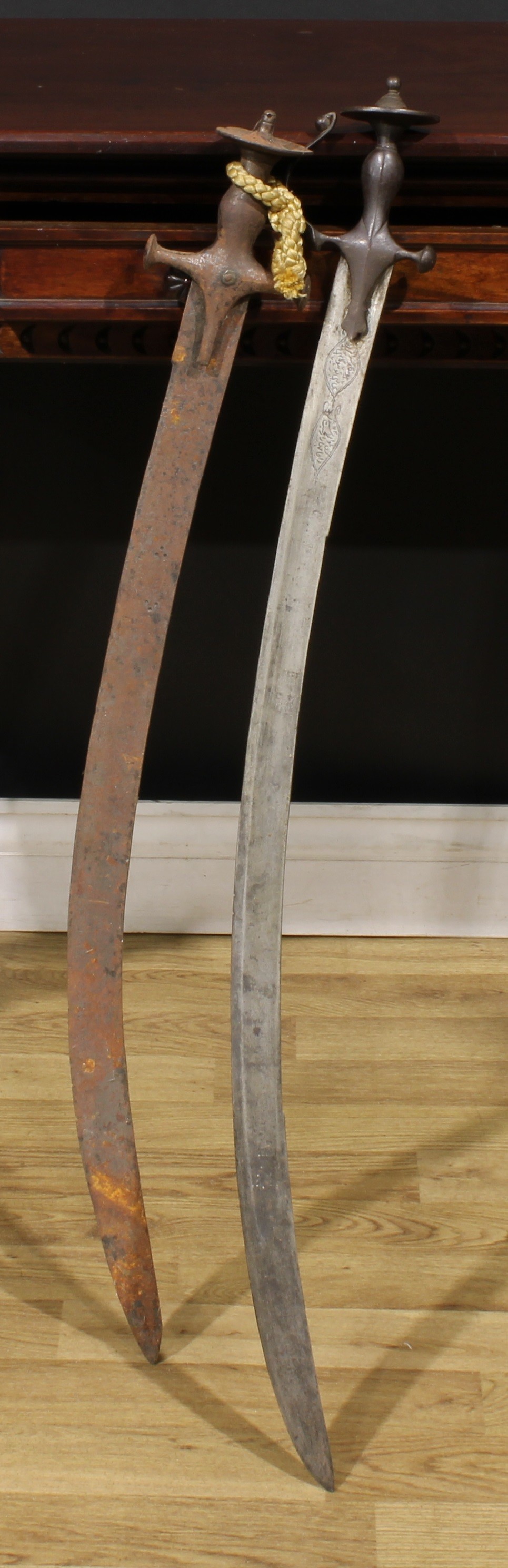 From the collection of Alan Dunmore, Old rectory, Rangemore, Staffordshire  A 19th century Indian talwar, 81cm curved blade inscribed with two panels of verse, bowed knuckle guard, disc pommel, 94cm long overall; another (2)