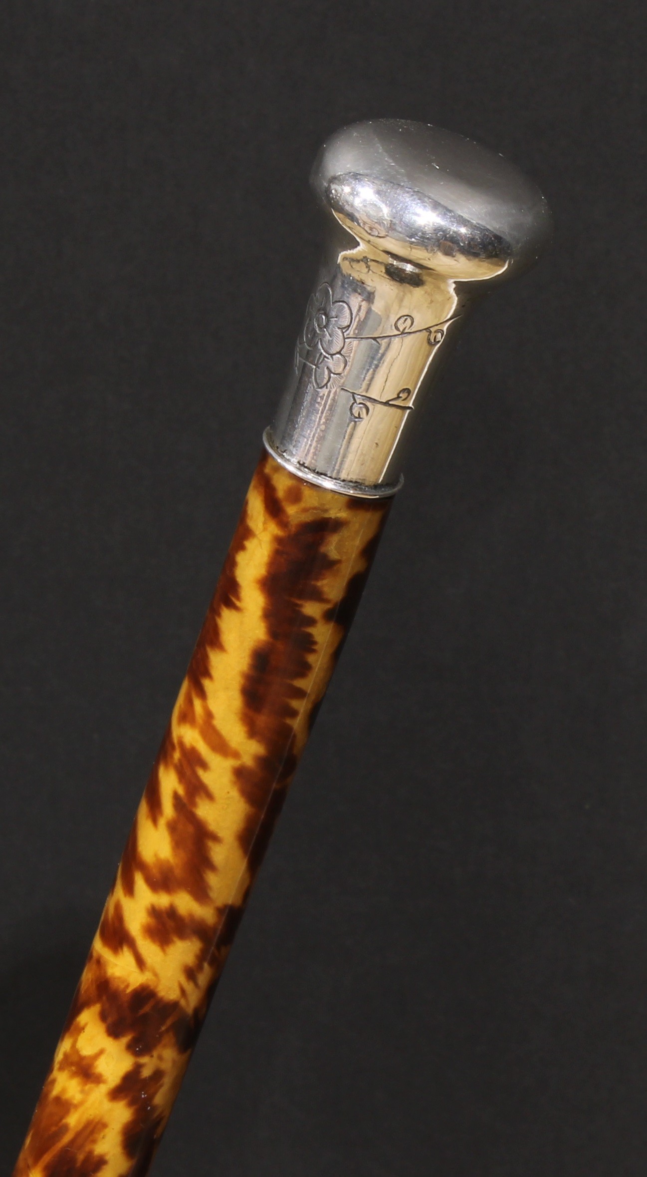 A 19th century tortoiseshell walking cane, the silver coloured metal pommel chased in the Aesthetic Movement taste with blossoming prunus, 88cm long, c.1880
