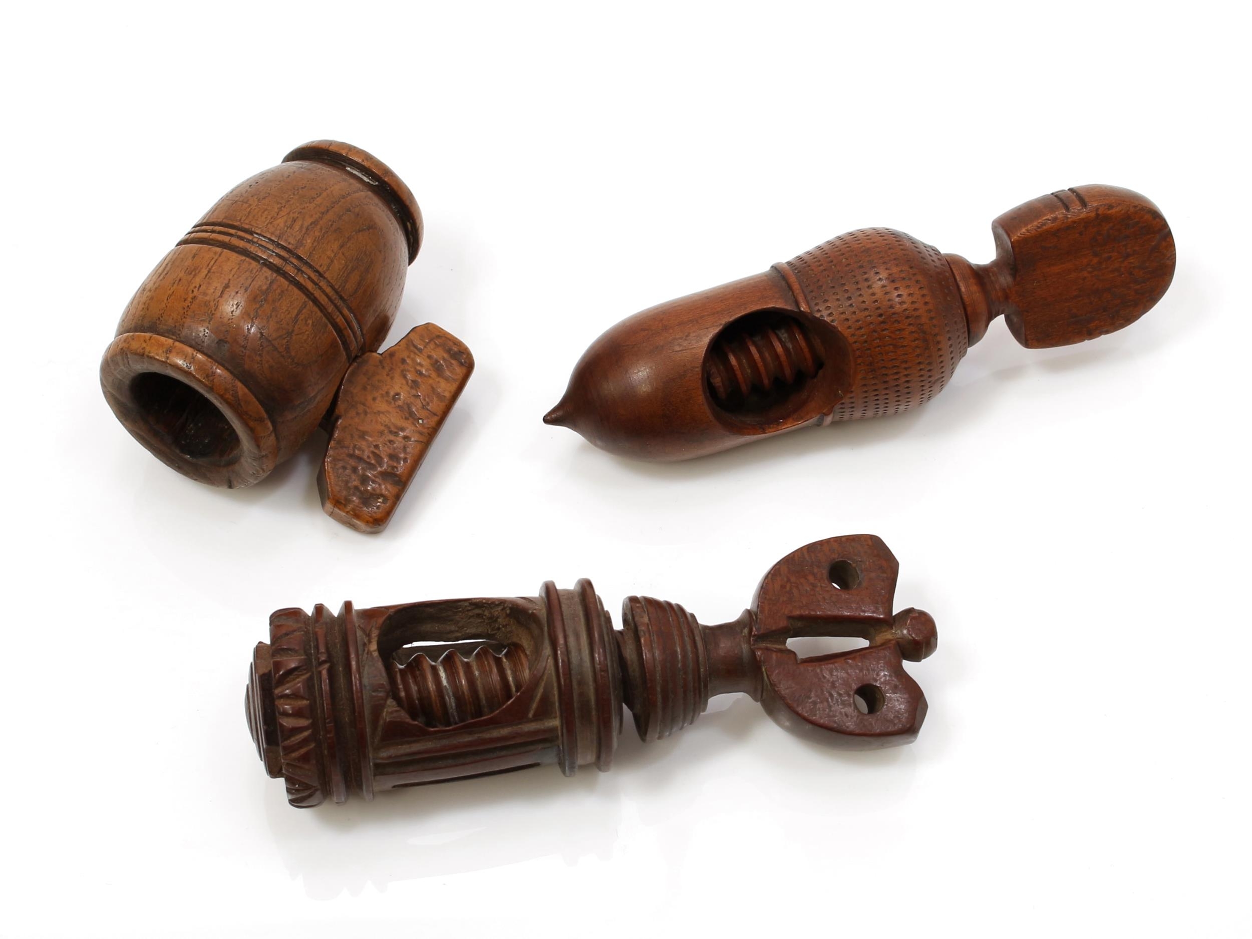 Nutcrackers - a 19th century turned acorn shaped screw-action pocket nut cracker, possibly fruitwood, 12cm long; another, oak; another, Continental (3)