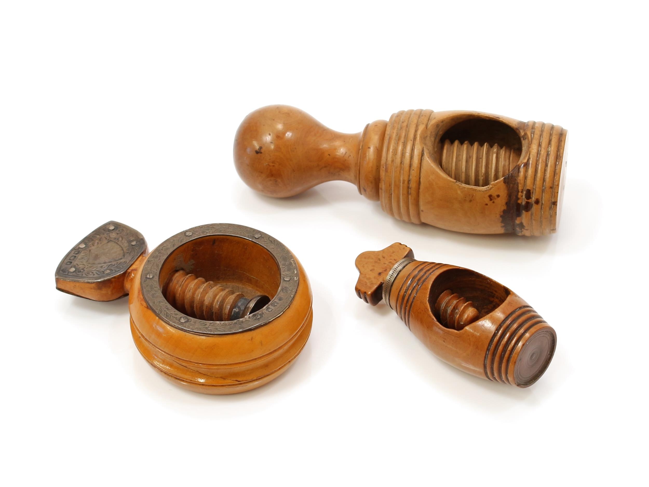 Nutcrackers - a Victorian silver mounted boxwood screw-action ring shaped pocket nut cracker, 5cm diam, the fittings Martin, Hall & Co, Sheffield 1890; a 19th century French boxwood screw-action nut cracker, barrel shaped recticle, 10.5cm long; another similar pocket corkscrew (3)
