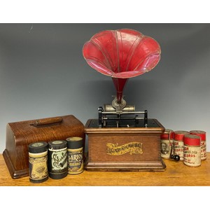 An early 20th century phonograph, The Columbia Gramophone, red painted tin horn, oak case, 31cm wide; a collection of wax phonograph cylinders, mostly Edison Gold Moulded Recorders and Clarion Records, cardboard tubes (approx 24)