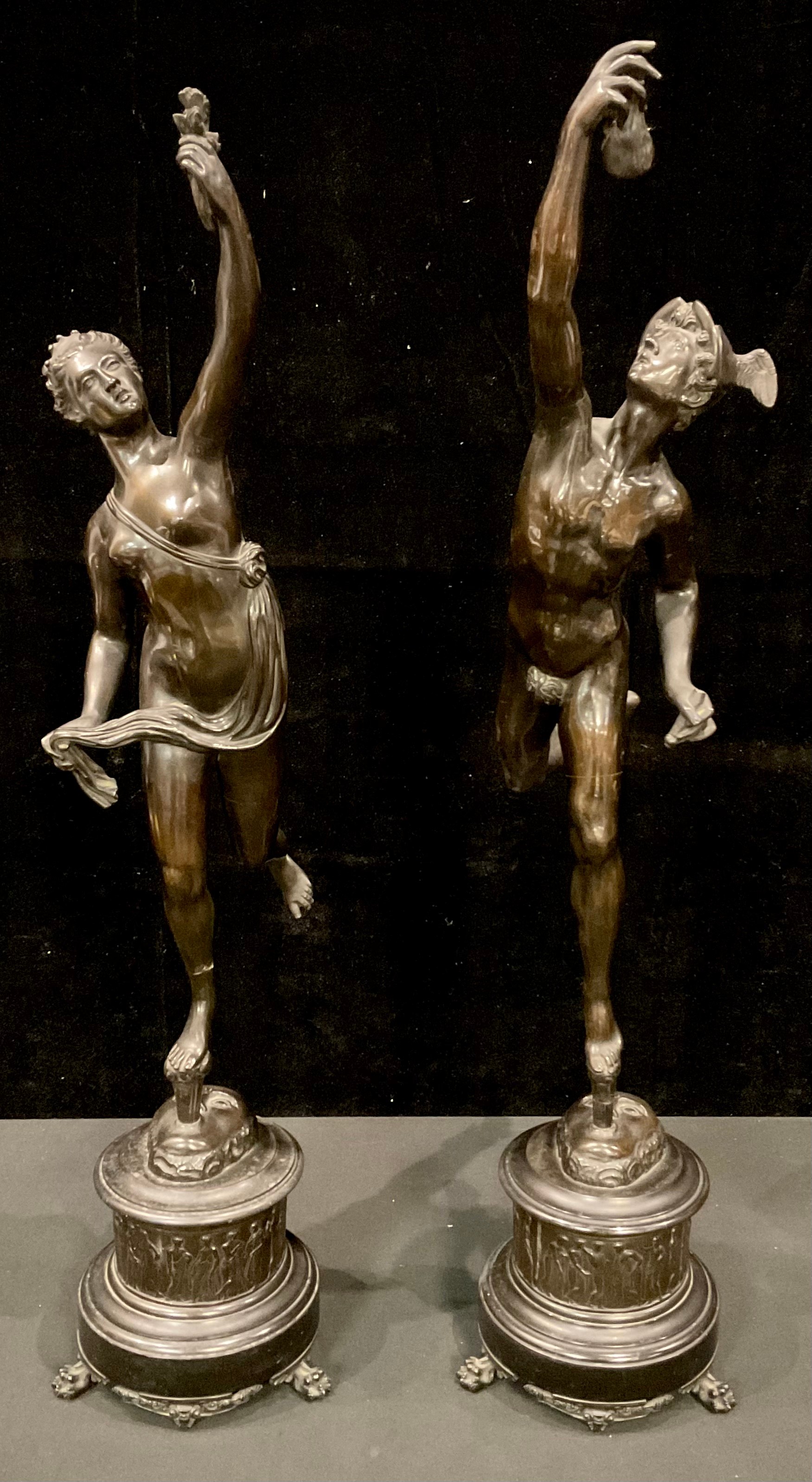 Giambologna (Italian, 1529-1608), after, a pair of dark patinated bronze sculptures, Mercury and Fortuna, each standing nude on one leg balancing on a gust of wind from the mouth of Zephyrus, cylindrical stepped bronze and black marble bases, paw feet, 81 and 78cm high
