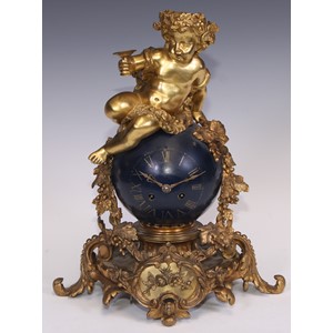 A Napoleon III ormolu and japanned mantel clock, cast as a Bacchic putto atop a celestial orb draped with fruiting vine, twin winding holes, eight-day movement by Rollin, Paris striking on a bell, acanthus scroll base, 35cm high, c.1860