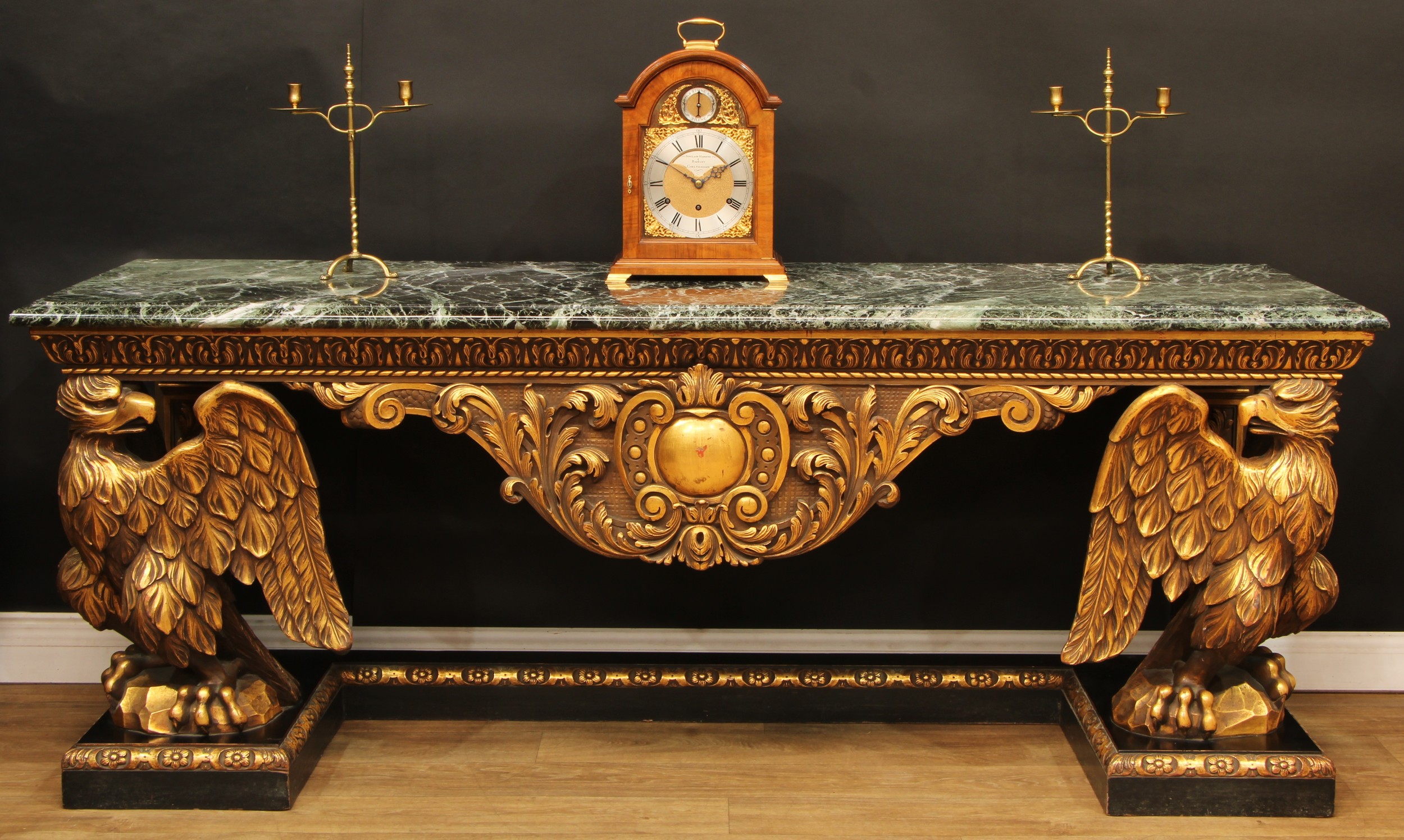 A large George II design giltwood and ebonised console table, in the manner of William Kent, rectangular Guatemala type green marble top above a leafy frieze, shaped apron with vacant cartouche and scrolling acanthus flanked by bold eagle supports, plinth base, 83cm high, 213.5cm wide, 65cm deep, 20th century