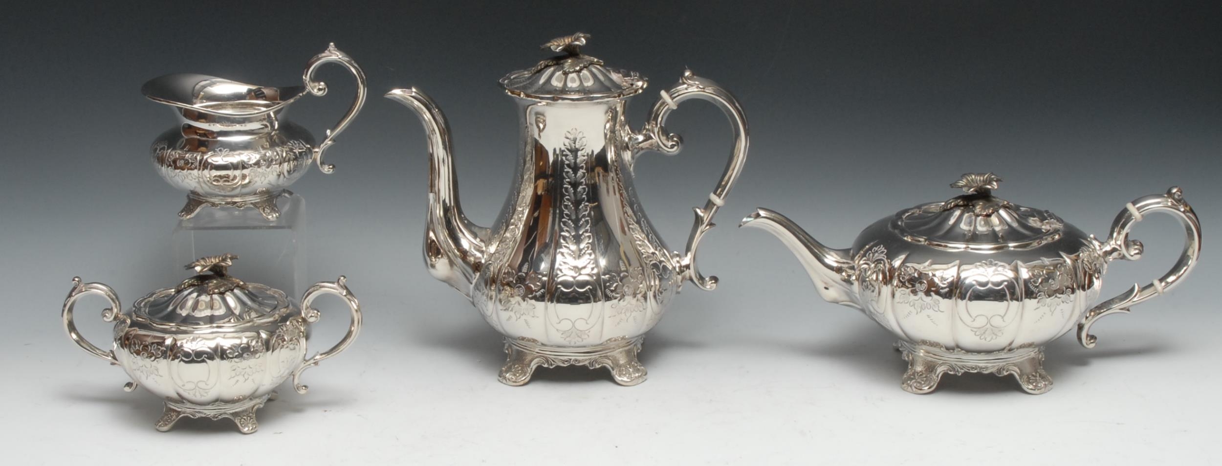 A Victorian style silver four piece melon shaped tea and coffee service, comprising teapot, milk jug and sucrier, each engraved with flowers and stiff leaves, the coffee pot 24cm high, EHP Co Ltd, Sheffield 1975, 3164g gross