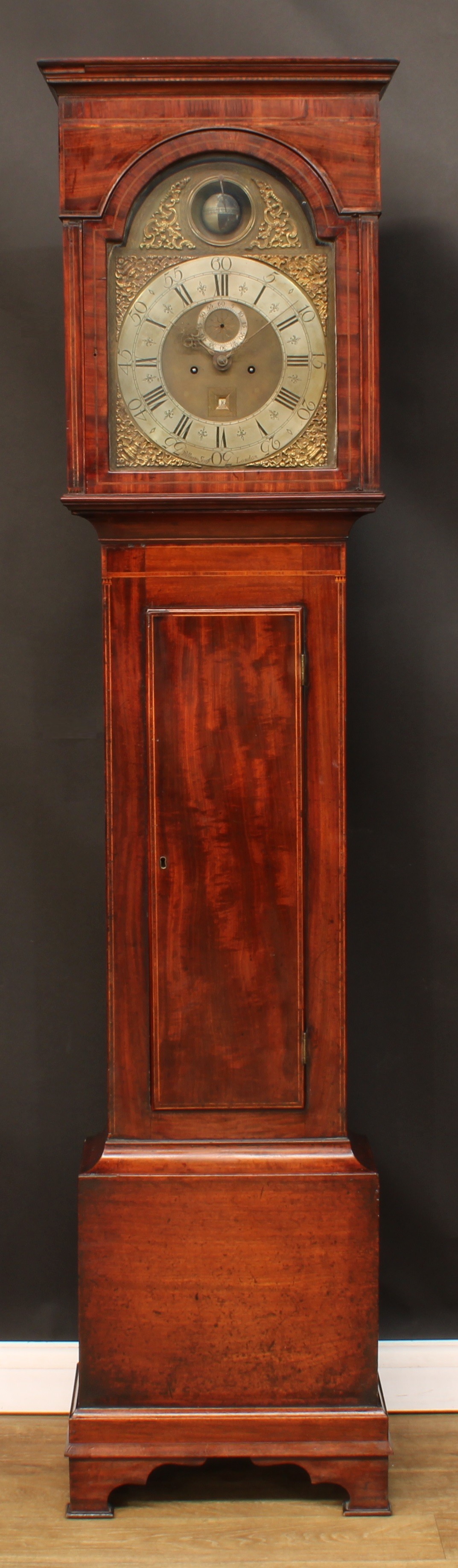 A George II mahogany longcase equation clock, 33.5cm arched brass dial with silvered chapter ring inscribed William Scafe, London, the arch with rotating orb delineated to demonstrate the current difference between solar and mean time, Roman and Arabic numerals, subsidiary seconds dial, date aperture, twin winding holes, eight-day movement striking the previous hour on two bells at the half hour, the flat topped hood with moulded cornice, rectangular door to waist, outlined throughout with boxwood stringing, ogee bracket feet, 214cm high, 52.5cm wide, 27cm deep, c.1745  William Scafe, an eminent maker of considerable repute, was born son of a blacksmith at Bushley, Yorkshire in 1687, and was apprenticed to his father before moving to London c.1710 setting up in at the sign of the Clock in King Street later moving to Milk Street, Cheapside, and becoming free of the Clockmakers' Company in 1721, and served as its master 1749-1764. He had apprentices in 1735 and 1748 dying in 1765 (will proved 7th June). Despite his unusually long career, his clocks are remarkably scarce [see Loomes, B., The Mystery of William Scafe in Clocks Magazine (Jan. 1988) 16-18]