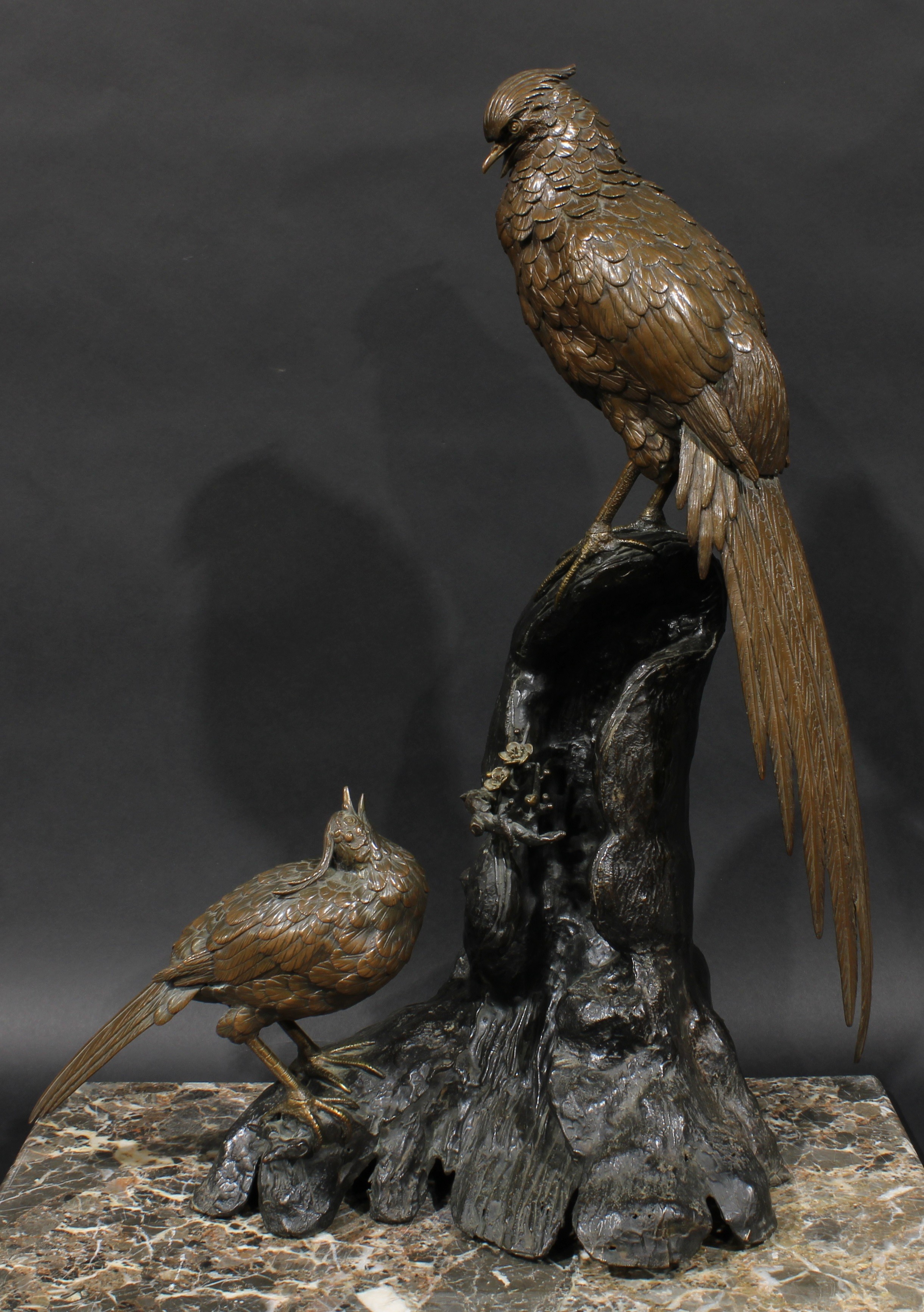 Japanese School (Meiji period), a large brown patinated bronze group, exotic birds perched on a prunus root, 72cm high