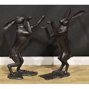 A pair of contemporary dark patinated bronzed metal models, boxing hares, the largest 85cm high, the other 77cm high