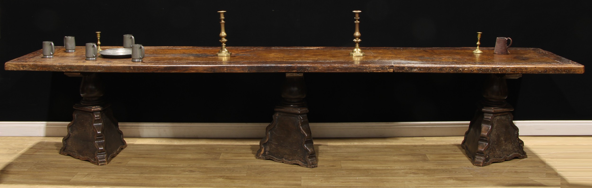 An 18th century Southern European triple-pedestal refectory table, one plank top with cleated border, shaped triform pillars, 75cm high, 382cm long, 79cm wide, c.1720