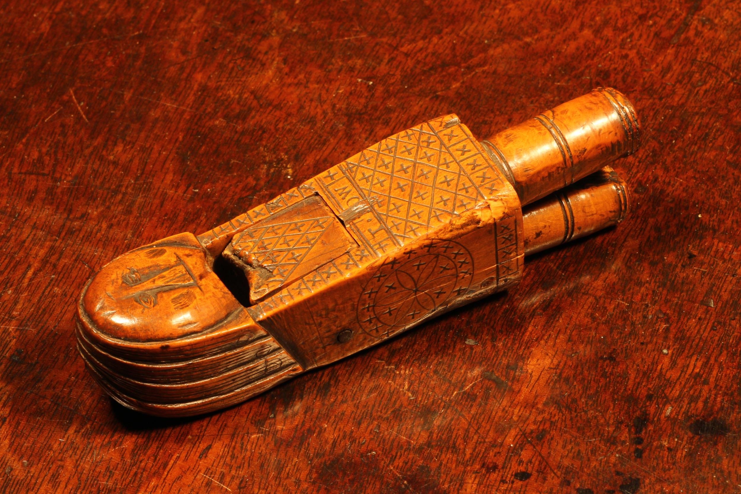 Nutcrackers - a 17th century boxwood figural lever-action nut cracker, as a stylised knight, his rudimentary body punched and incise carved with a field of crosses, the sides with sgrafito daisy wheels, 12.5cm long, inscribed T Row and dated 1692   Reference: Wagner, Arlene, The Art & Character of Nuutcrackers,  Collectors Press, Inc, Portland 2005, p. 14