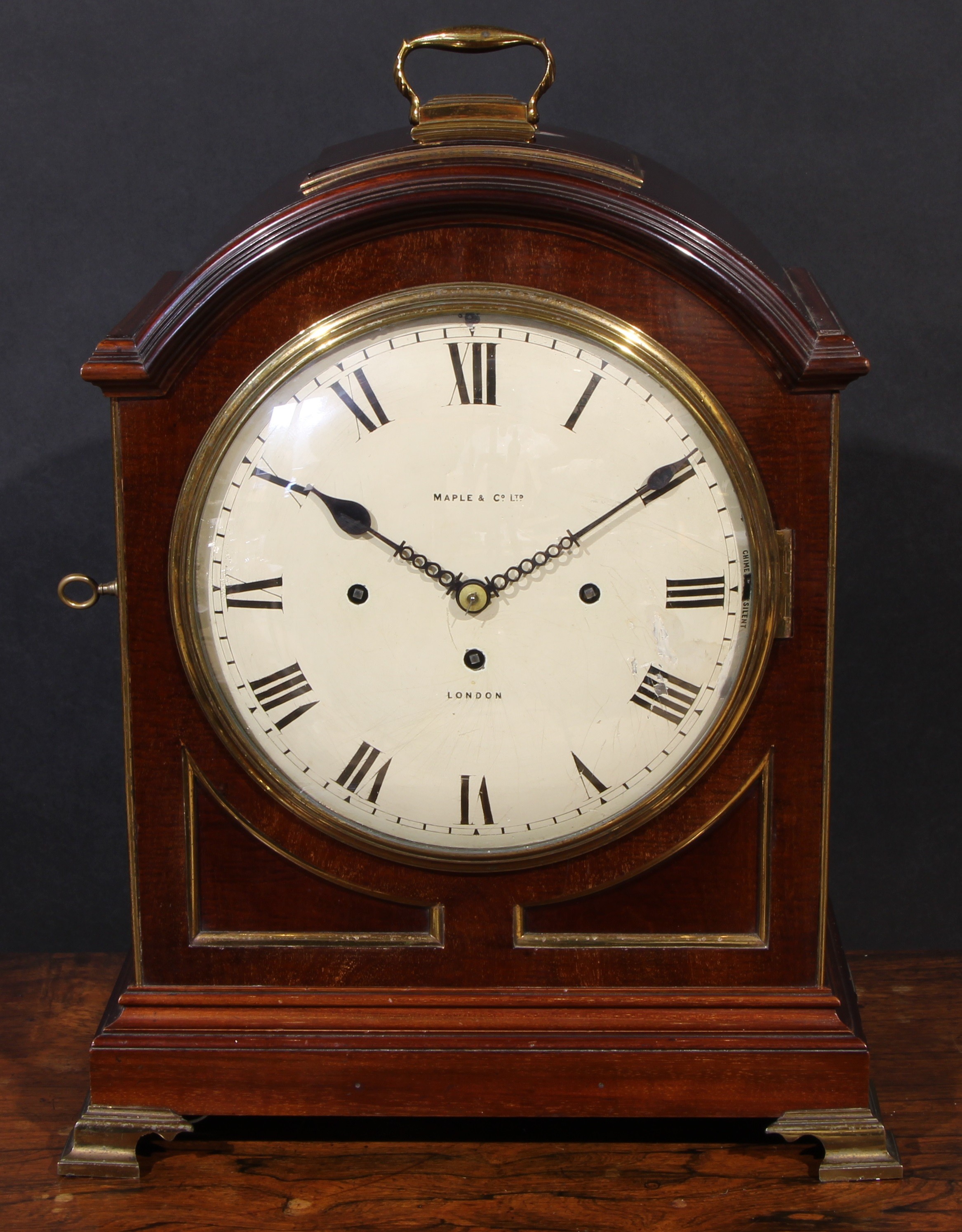A late Victorian mahogany musical repeating bracket clock, in George III Revival style, 26cm convex painted dial inscribed Maple & Co Ltd, London, Roman numerals, three winding holes, Chime/Silent to side, the triple-fusee movement with pull-repeat, striking and chiming on gongs, the arched case with brass carrying handle and ogee bracket feet, 53cm high overall, c.1890
