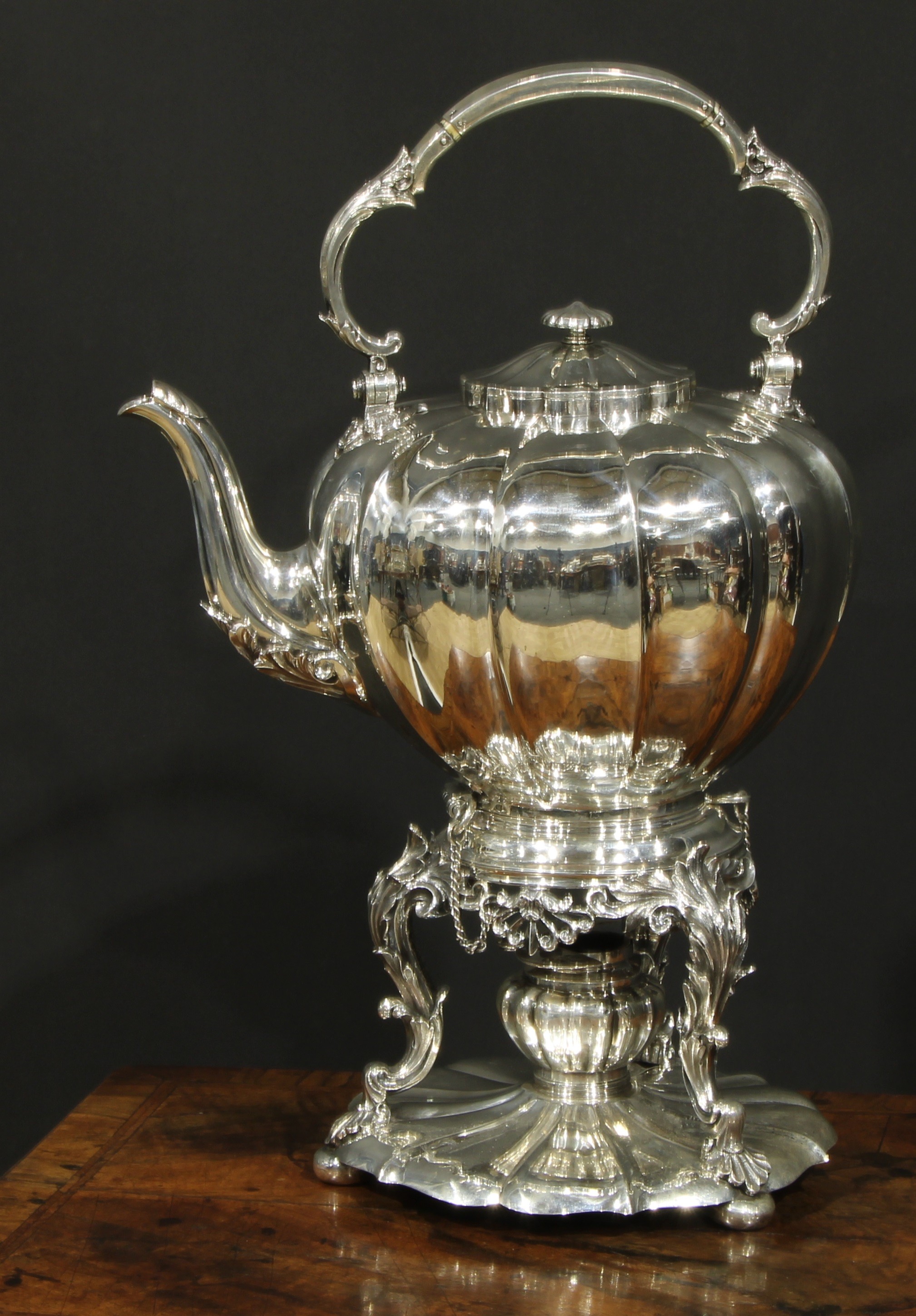 A large early Victorian Rococo Revival silver melon shaped tea kettle, stand and burner, swing handle, hinged cover, anthemion apron and acanthus scroll legs, fluted circular base, John Tapley, London 1845, 3902g  Heraldry: Arms and motto of the Rundle family, and as used by the silversmith Philip Rundell