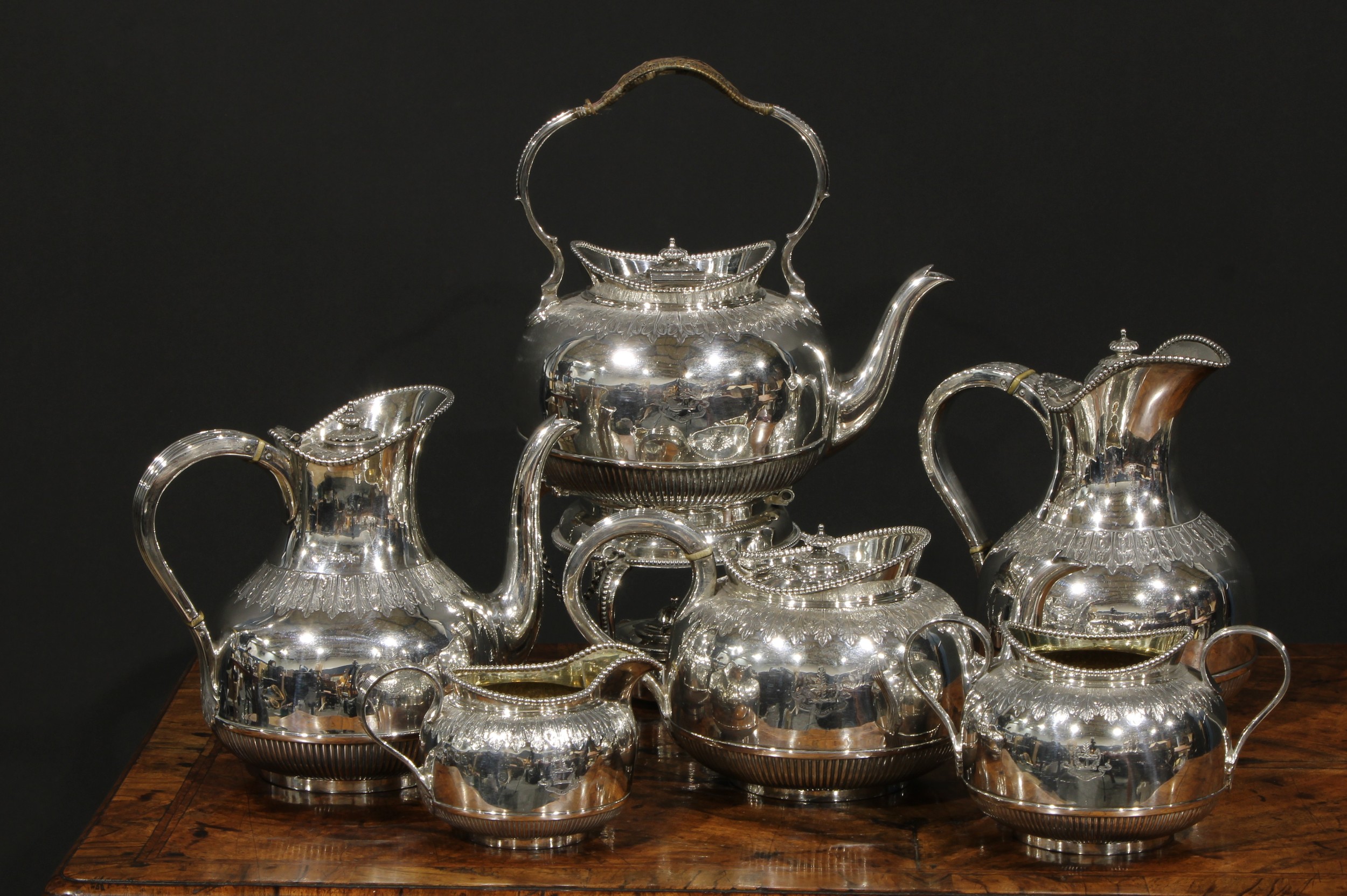 A late Victorian/Edwardian silver six piece Cape pattern tea and coffee service, comprising teapot, coffee pot, spirit kettle, hot water pot, milk jug and sugar basin, each part-fluted, with beaded borders and chased with a band of crisp acanthus, the kettle 35cm high overall, Goldsmiths & Silversmiths Company Ltd, London 1900, 1902 & 1903, the water pot Martin, Hall & Co, Sheffield 1901