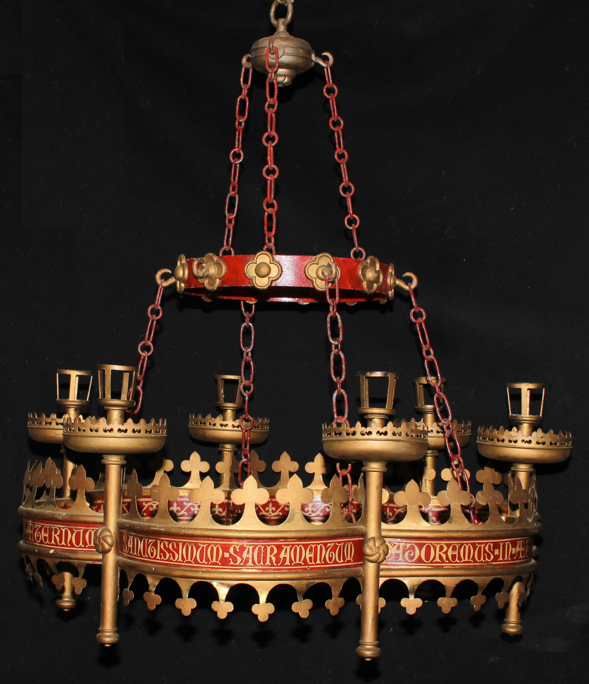 An important mid-19th century Gothic Revival brass, iron and painted ecclesiastic chandelier or corona lucis by Augustus Welby Northmore Pugin, removed in the 1930s from St Giles Church, Cheadle (which was designed by Pugin), probably made by John Hardman and Co, Birmingham, inscribed 'Adoremus in Aeternum Sanctissimum Sacramentum', chain suspensions, 94cm diameter