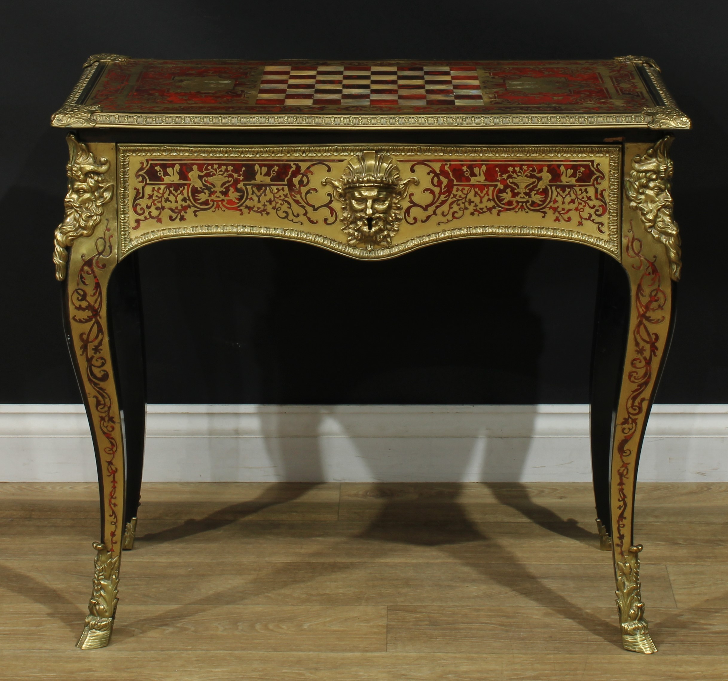 A 19th century Franglais gilt-bronze mounted tortoiseshell, brass and mother of pearl marquetry centre table, in the manner of André-Charles Boulle, rectangular top inlaid with scrolling and trailing leaves and chinoiserie and mythical depictions with a Chinese liuqin player and his dancing companion, birds and further figures, the centre inlaid for chess, above a long frieze drawer, each frieze and angle cast and applied with a bearded mask, French cabriole legs, bestial hoof sabots, 72cm high, 78.5cm wide, 45cm deep, c.1850