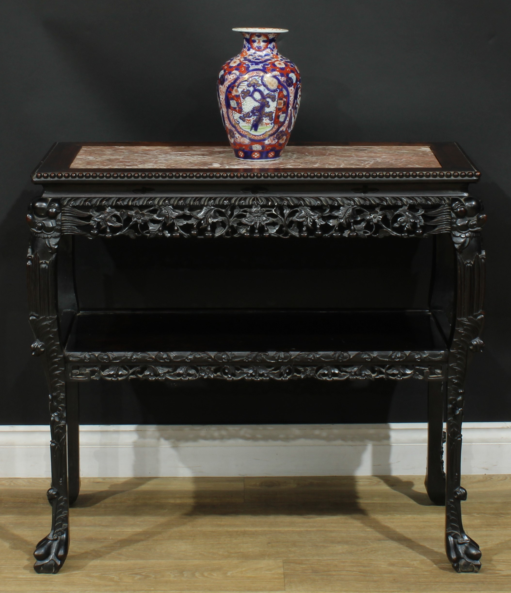 A Chinese hardwood porcelain table, rectangular top with beaded border and inset marble panel above a shaped frieze pierced and carved with flowers and fruiting branches, cabriole legs, open undertier, ball and claw feet, 80cm high, 87.5cm wide, 43.5cm deep