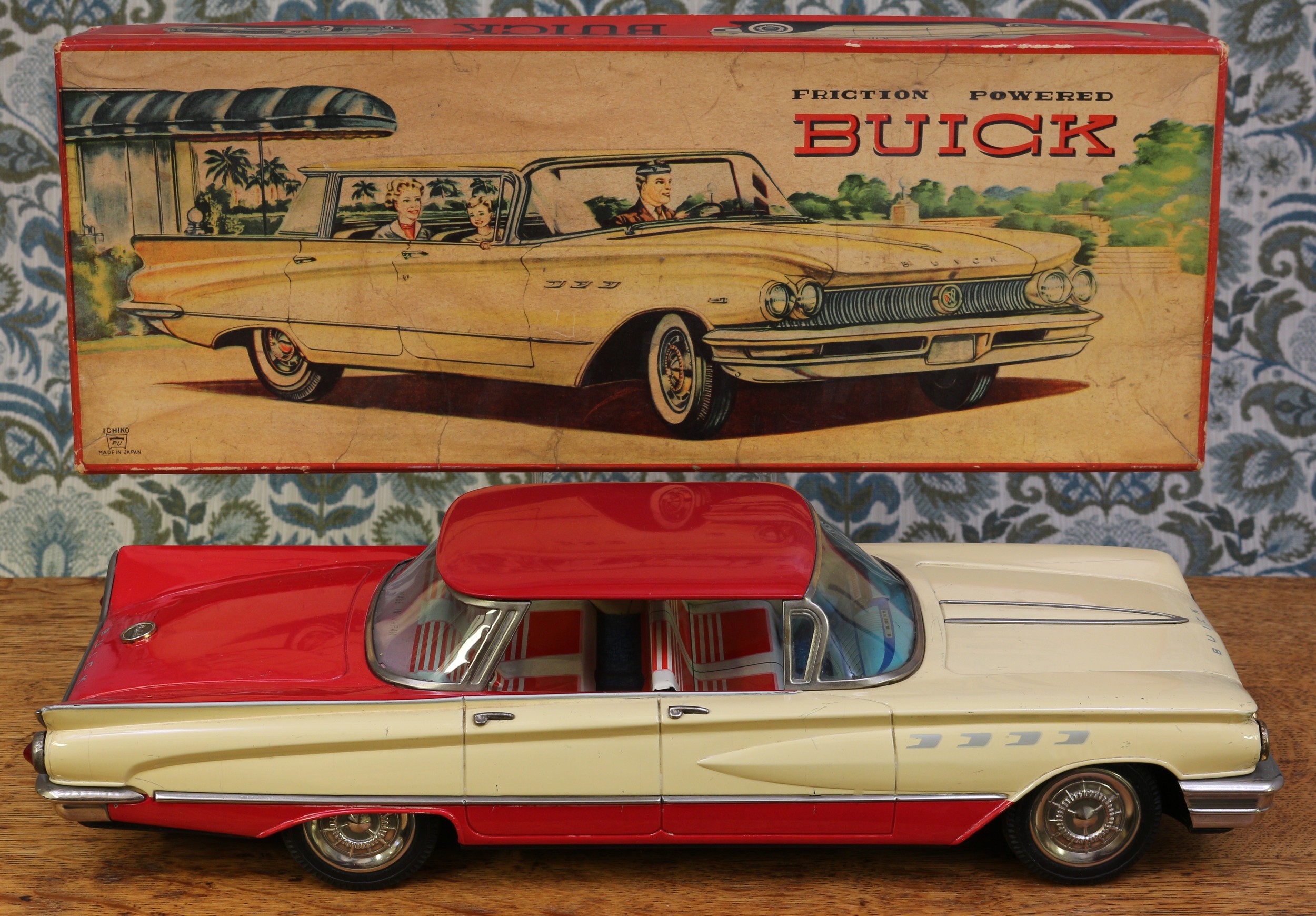 A 1960's Ichiko (Japan) tinplate and friction powered Buick, two tone red and cream body with lithographed detail to the interior, 44cm long, boxed