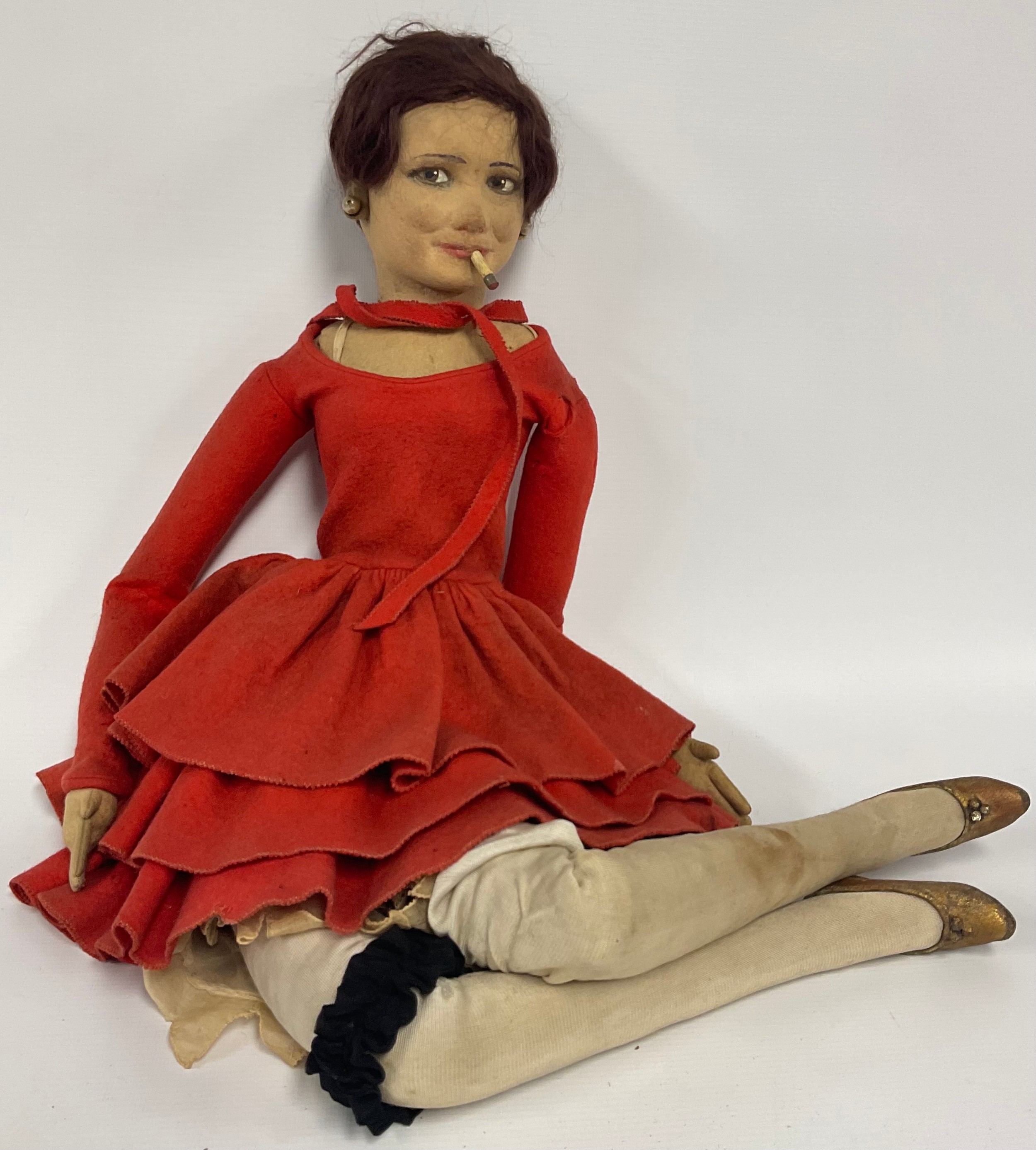 A Lenci Boudoir Doll, as a tall slender lady smoking, with short auburn hair, earrings, red felt dress, stockings and garter belt, heeled gold shoes, 78cm high, c.1930
