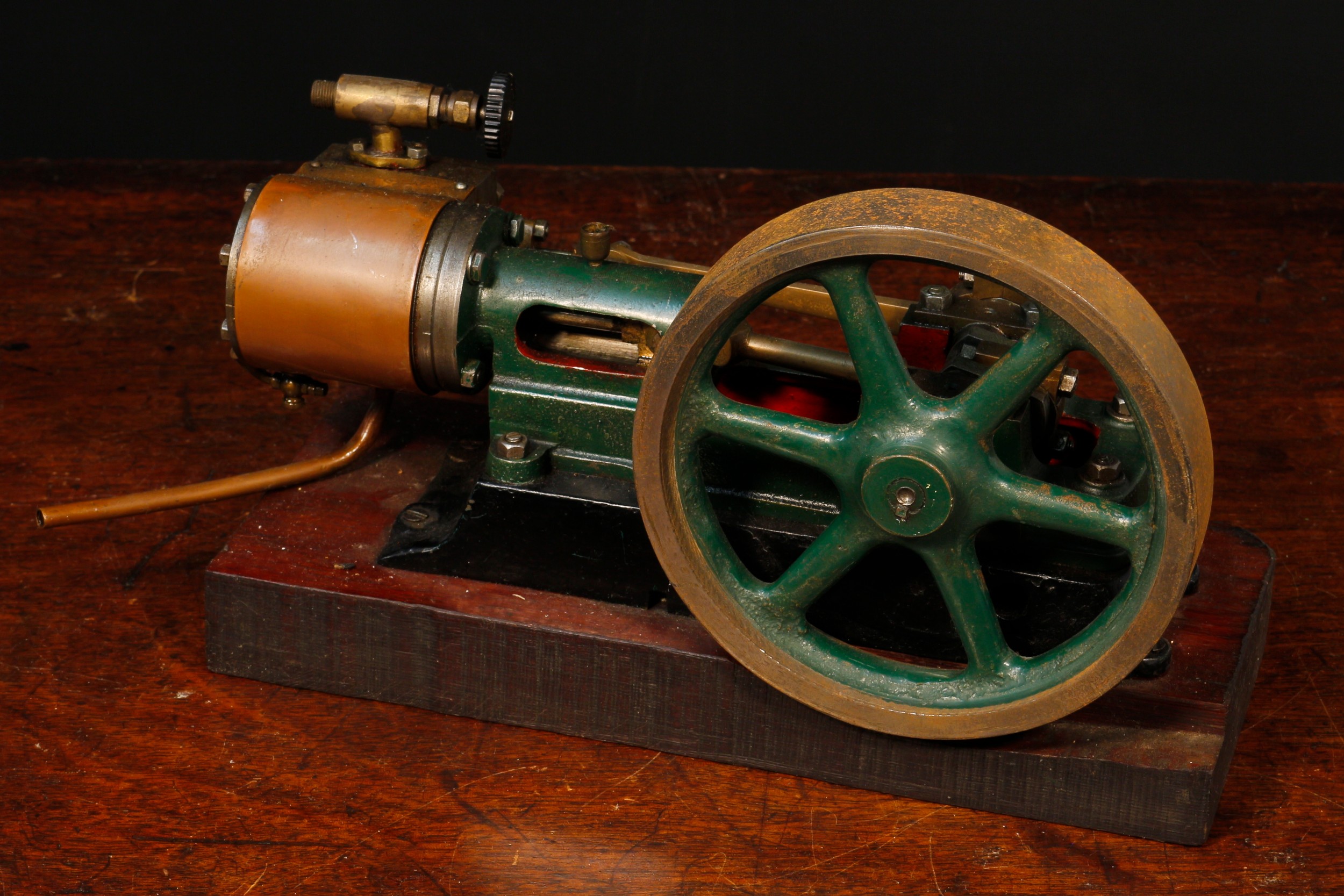 Live Steam - a live steam horizontal stationary steam mill engine, painted in green and red, the lower section painted black, 4.5" diameter six spoke flywheel, mounted on a rectangular shaped wooden base, 13.5cm high, 22cm wide, 9cm deep