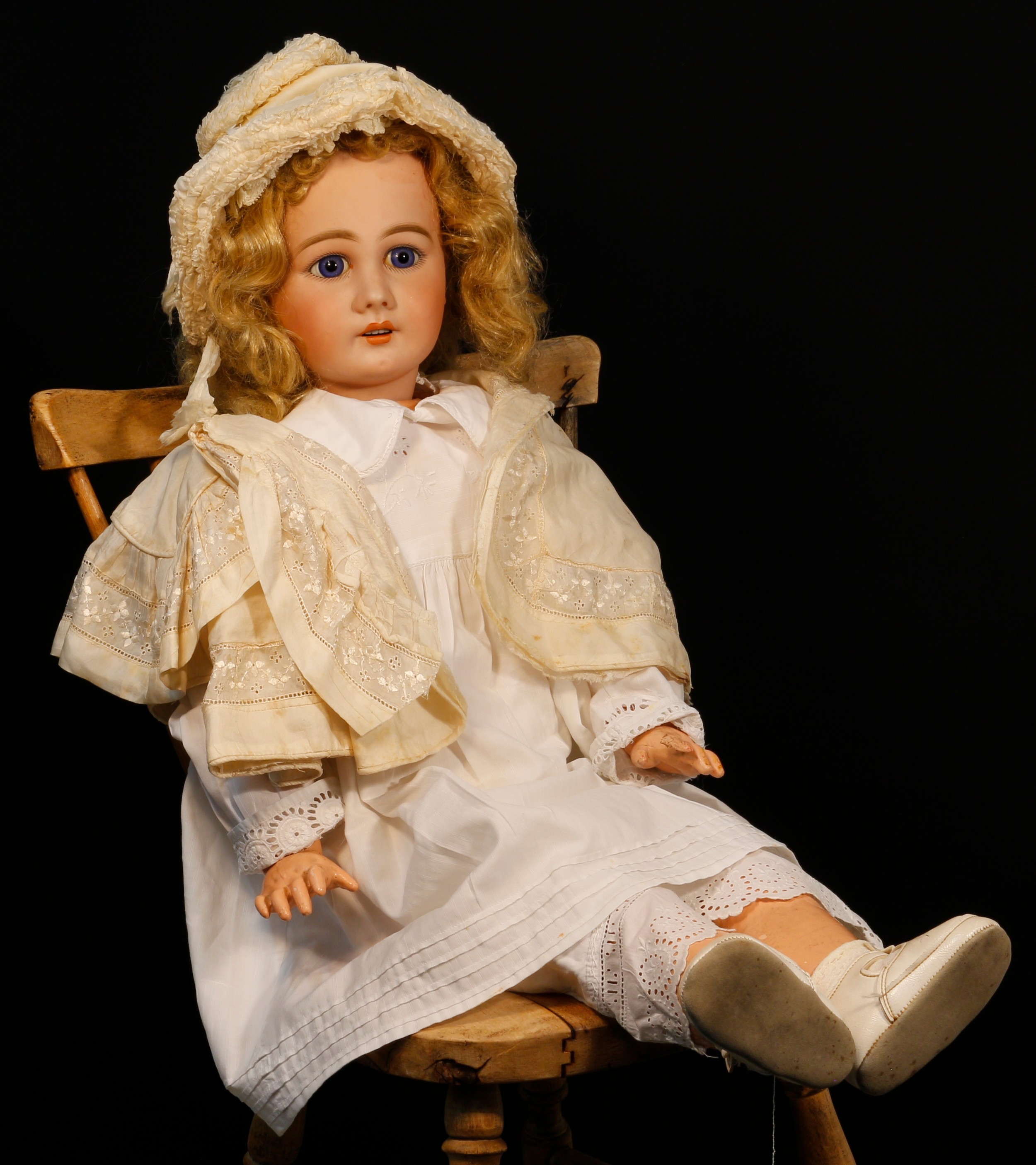 A Simon & Halbig (Germany) bisque head and painted composition bodied doll, the bisque head inset with fixed blue glass eyes, painted features including thick feathered brown eyebrows, fine eyelashes, blush cheeks and red lips, open mouth revealing upper teeth, blonde wig, pierced ears, impressed marks 'S16H, 939', 76cm high