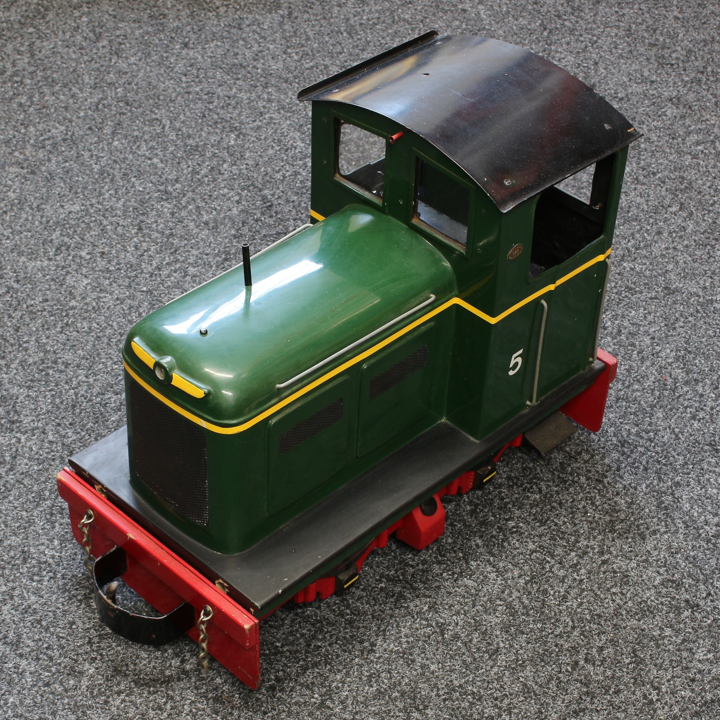 A Maxitrak 5 inch gauge 0-4-0 "Simplicity" electric locomotive, green livery, No.5, fitted with a Yuasa 12V 30Ah valve regulated lead acid battery, 66cm long; together with a passenger cart, 81cm long (2)