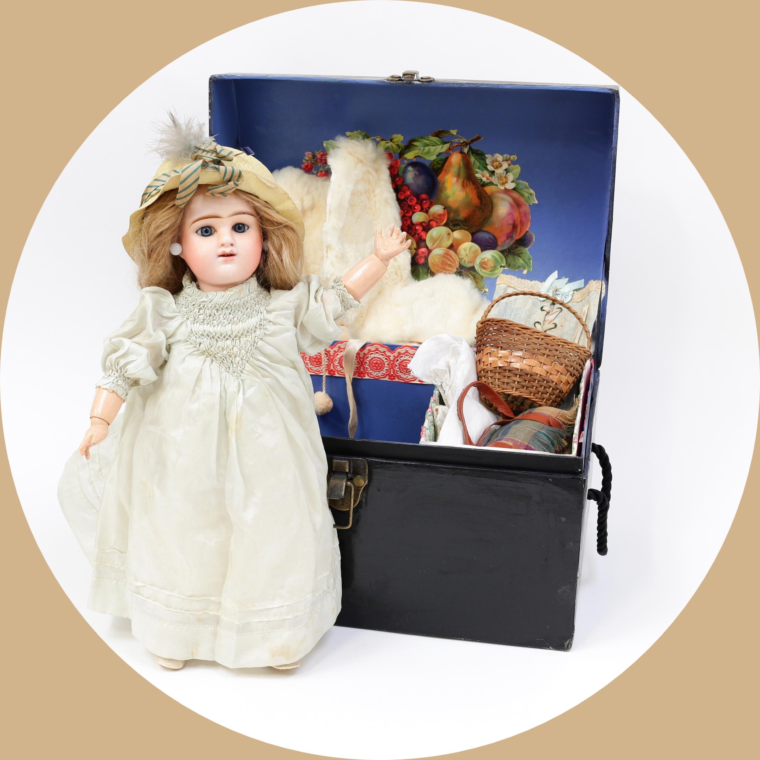 Toys From The Attic Part II - an Etienne Denamur (France) bisque head and painted composition bodied Bébé doll, the bisque head inset with fixed blue glass eyes, painted features including feathered brown eyebrows, fine eyelashes and blush cheeks, open mouth revealing upper teeth, pierced ears, blonde wig on cardboard pate, impressed marks, 35.5cm high; together with a brown  domed top travel trunk of small proportions, the fitted interior with a small single lift out tray compartment with various doll clothing and accessories (quantity)