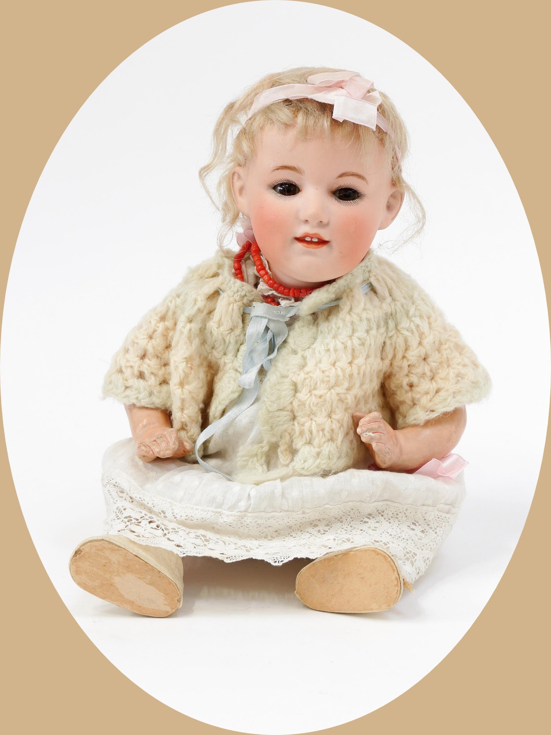 Toys From The Attic Part II - a Gebrüder Heubach (Germany) bisque head and painted composition bodied character doll, the bisque head inset with weighted sleeping brown glass eyes, painted features including thick feathered brown eyebrows, fine eyelashes and blush cheeks, moulded lips revealing two upper teeth, blonde wig on pate, impressed marks '7307, 5, GERMANY, [SUNBURST MARK]', 33cm high  For a similar example see Richter/Schmelcher, Heubach Character Dolls & figurines (Hobby House Press) ISBN: 0-87588-373-1, page 49.