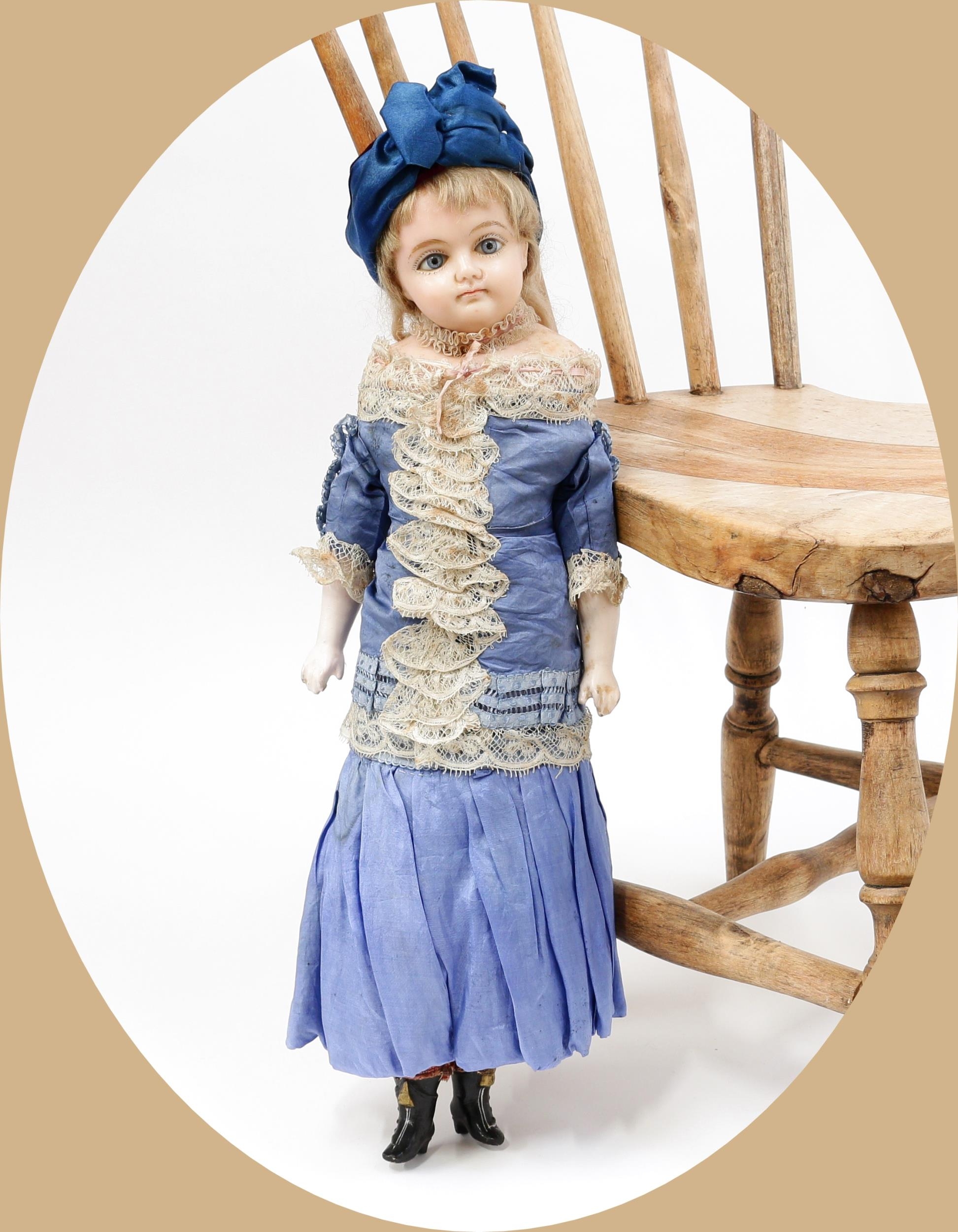 Toys From The Attic Part II - a 19th century wax over composition swivel head and shoulder doll, the wax over composition head inset with fixed blue glass eyes, painted features, blonde wig, partially stuffed cloth body with wax over composition lower arms and painted composition lower legs with shaped boots, 46cm high