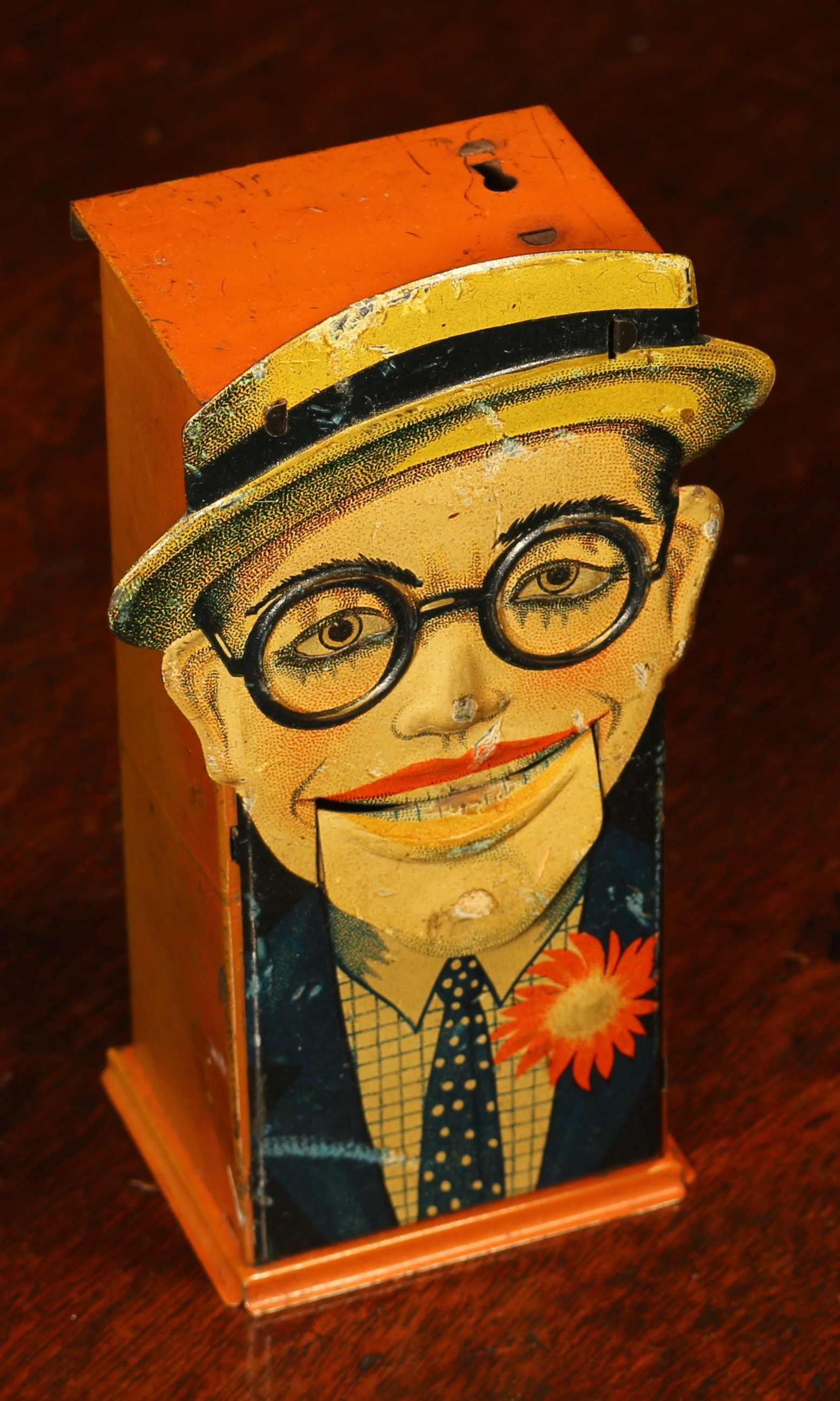 A 1920's tinplate novelty lever action mechanical money box or bank, lithographed detail, modelled as Harold Lloyd, probably manufactured by Saalheimer & Strauss, 13.5cm high  Reference - for a similar sold example see Special Auction Services, Toys For The Collector Auction, Newbury, Berkshire, 9th March 2016, Lot 370.