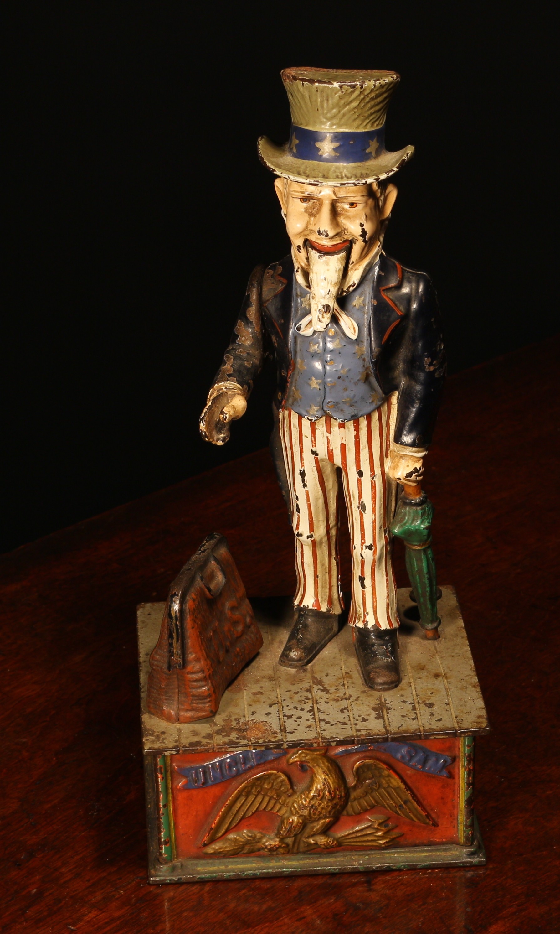 Americana - a late 19th century painted cast iron mechanical money box or bank, Uncle Sam Bank, modelled as the patriotic figure of Uncle Sam, raised upon a rectangular shaped plinth base, the pierced base plate inscribed 'PAT JUNE 8 1896', 29.5cm high
