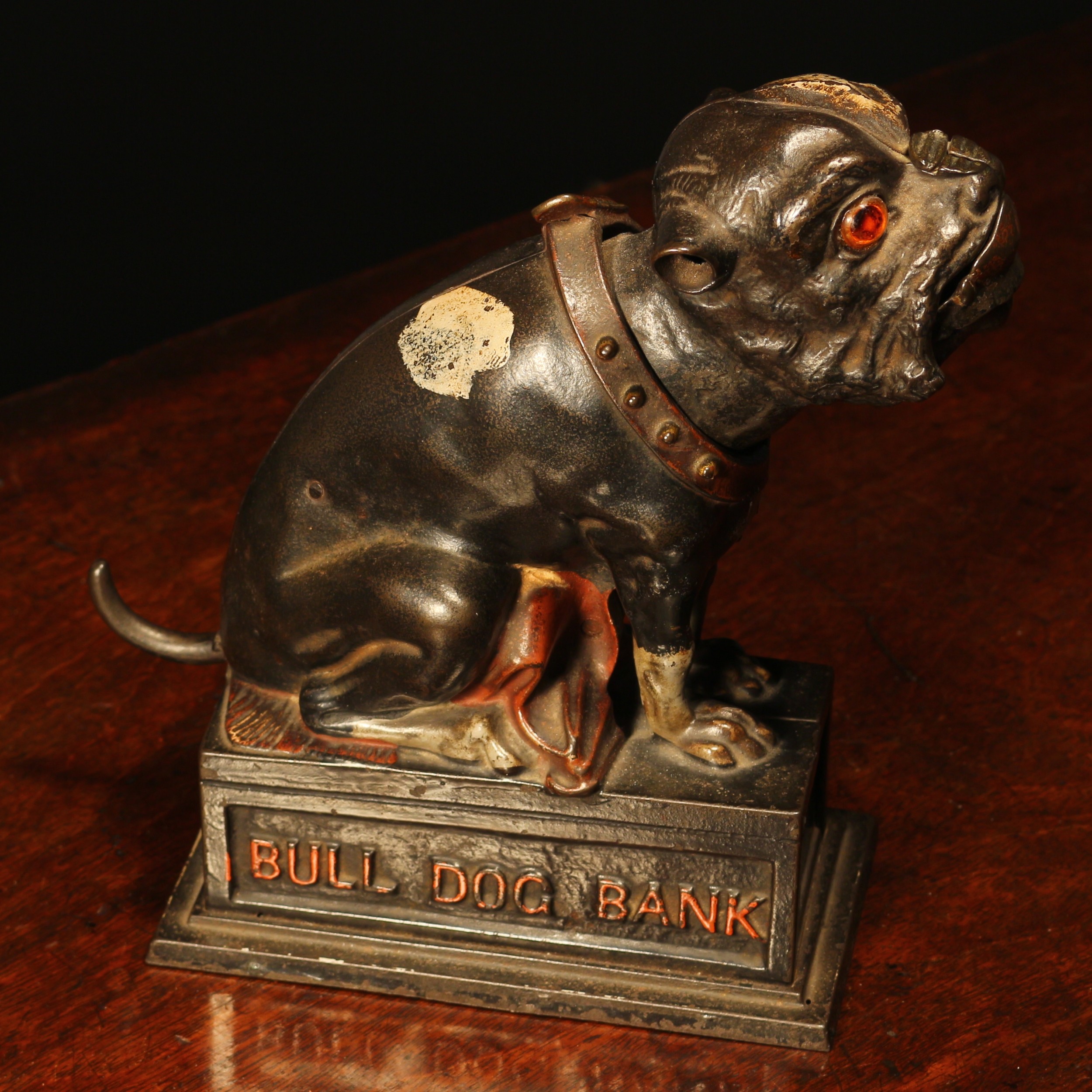 Americana - a late 19th century painted cast iron novelty mechanical money box or bank, Bull Dog Bank, modelled as a a seated Bull Dog, probably manufactured by J. & E. Stevens Co., mounted upon a rectangular shaped plinth base, the pierced base plate inscribed 'PATD APR 27 1880', 19.5cm high