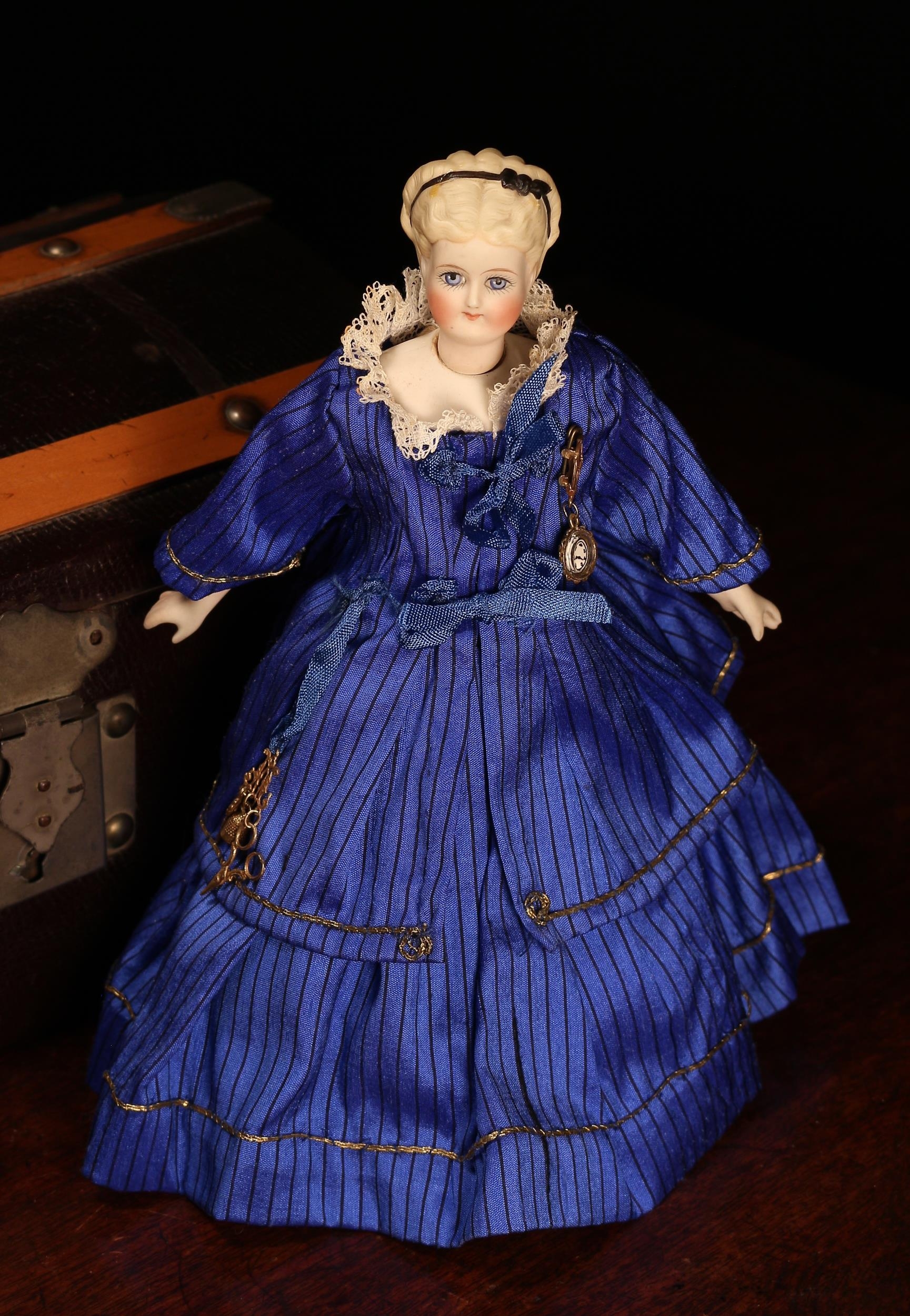 A 19th century unglazed Parian type swivel neck doll, of small proportions, unmarked but attributed to Simon & Halbig (Germany), the unglazed head with blonde moulded hair and black painted bow, painted features including feathered brown eyebrows, fine eyelashes, blue eyes, red lips and blush red cheeks, partially stuffed cloth body with unglazed bisque type lower arms and lower legs, 21.5cm high; together with a brown faux leather domed top rectangular shaped travelling trunk, with a single lift out tray, the case housing various doll clothing, miniatures and accessories (quantity)